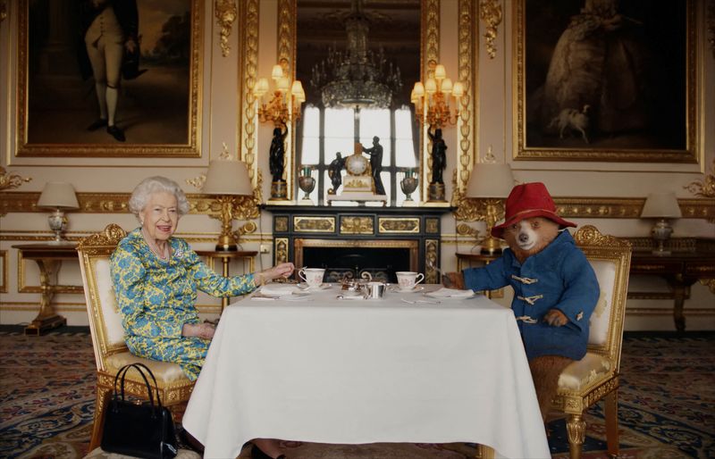 La reina Isabel de Reino Unido y el oso Paddington tomando un té con crema en el Palacio de Buckingham