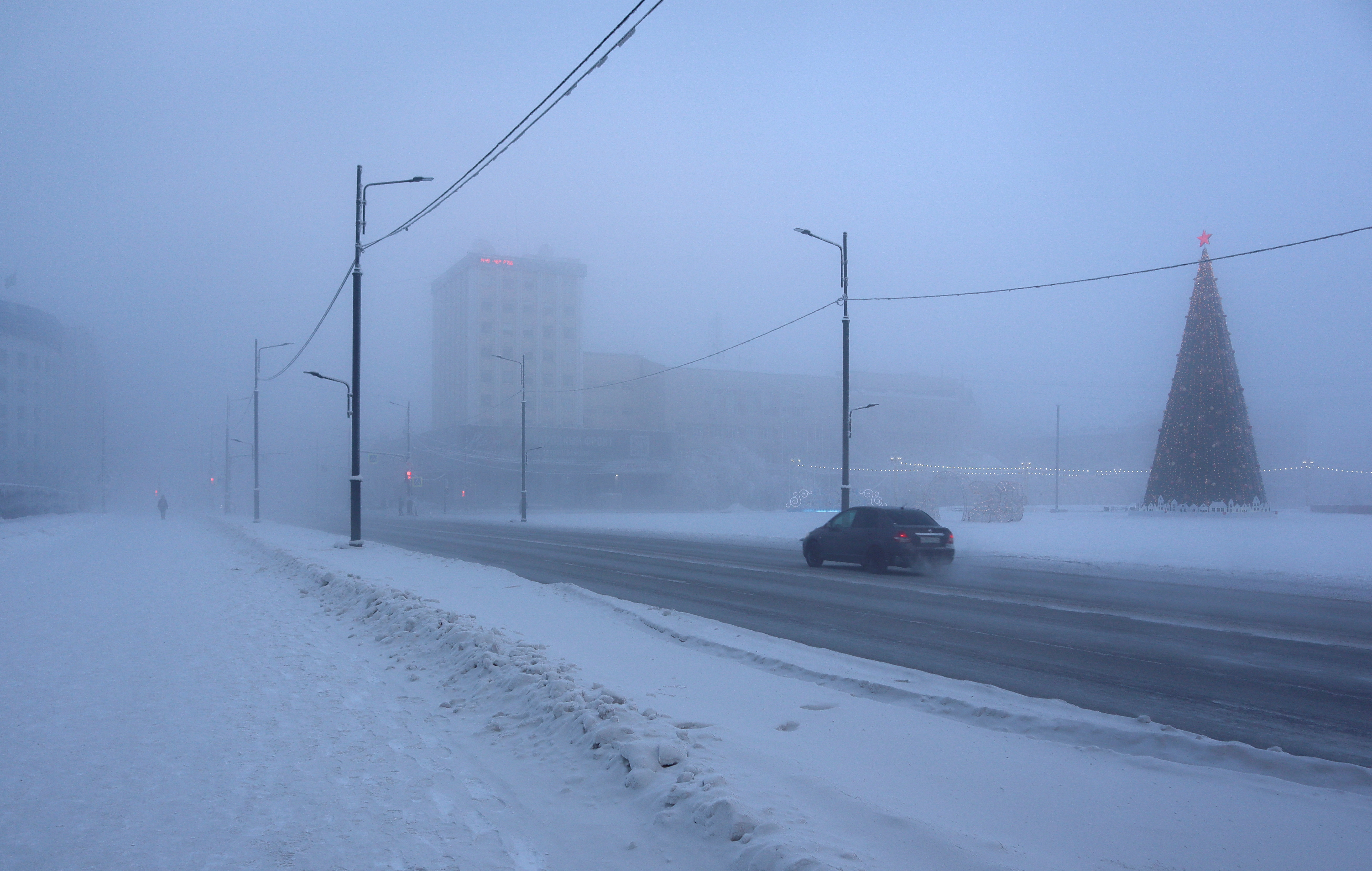 Un coche circula por una carretera en un día helado en Yakutsk, Rusia, este 15 de enero de 2023 (Reuters)