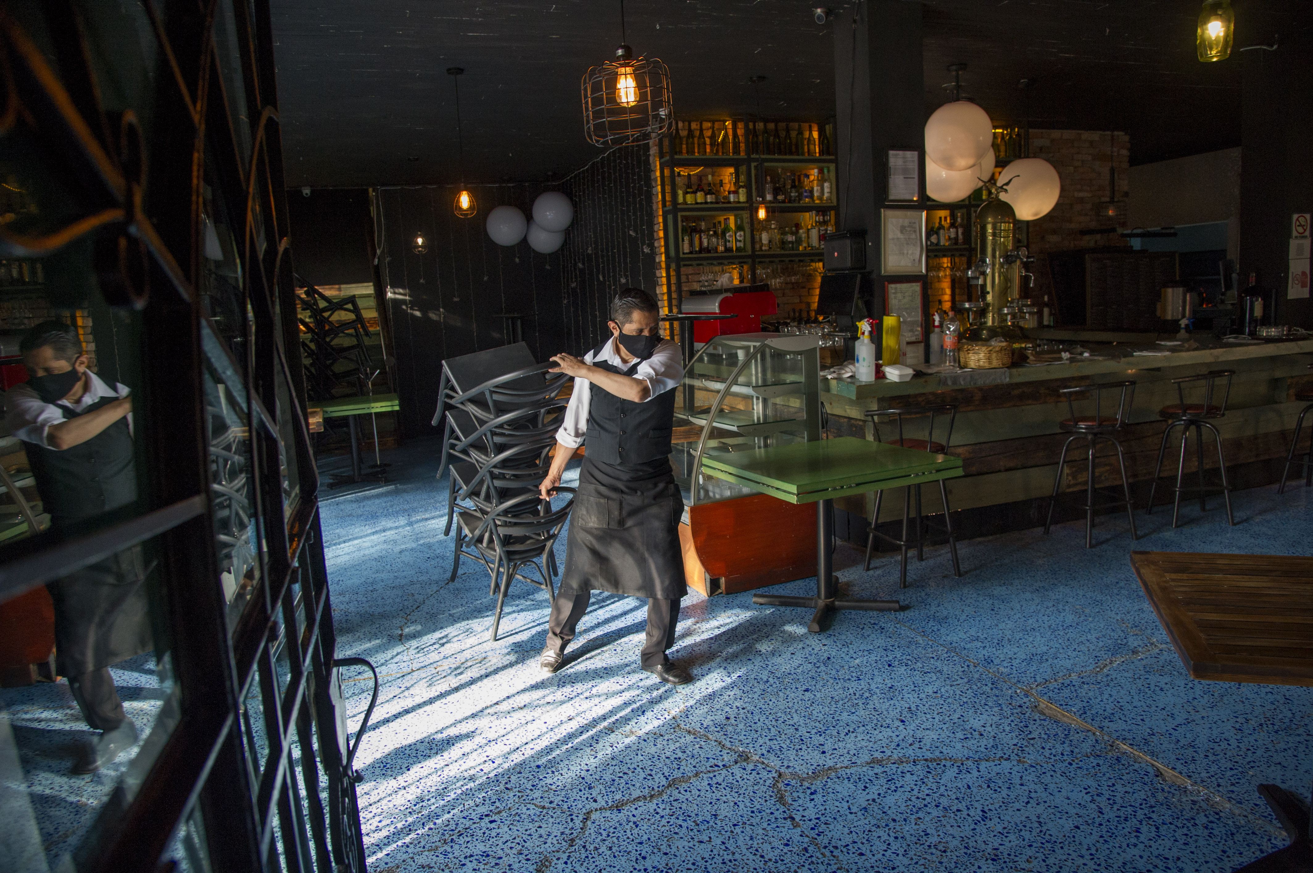 Un trabajador del restaurante Cabo Coyote organiza sillas en el barrio de Coyoacán, Ciudad de México, el 1 de julio de 2020 durante la pandemia COVID-19. (Foto: CLAUDIO CRUZ / AFP)