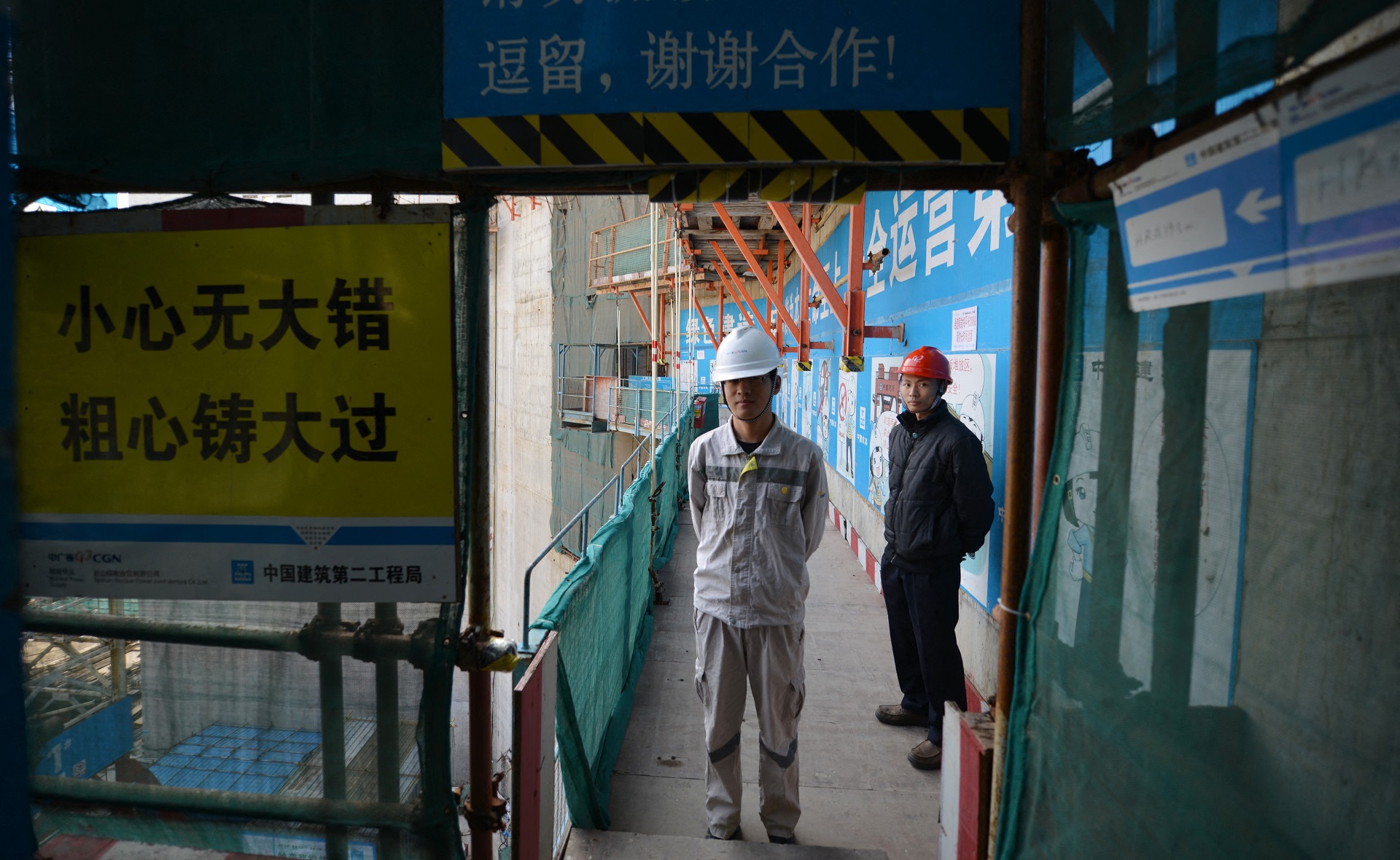 Trabajadores que esperan que el entonces primer ministro francés, Jean-Marc Ayrault, llegue a la central nuclear conjunta chino-francesa de Taishan, en las afueras de la ciudad de Taishan, en la provincia de Guangdong. (Photo by PETER PARKS / AFP)