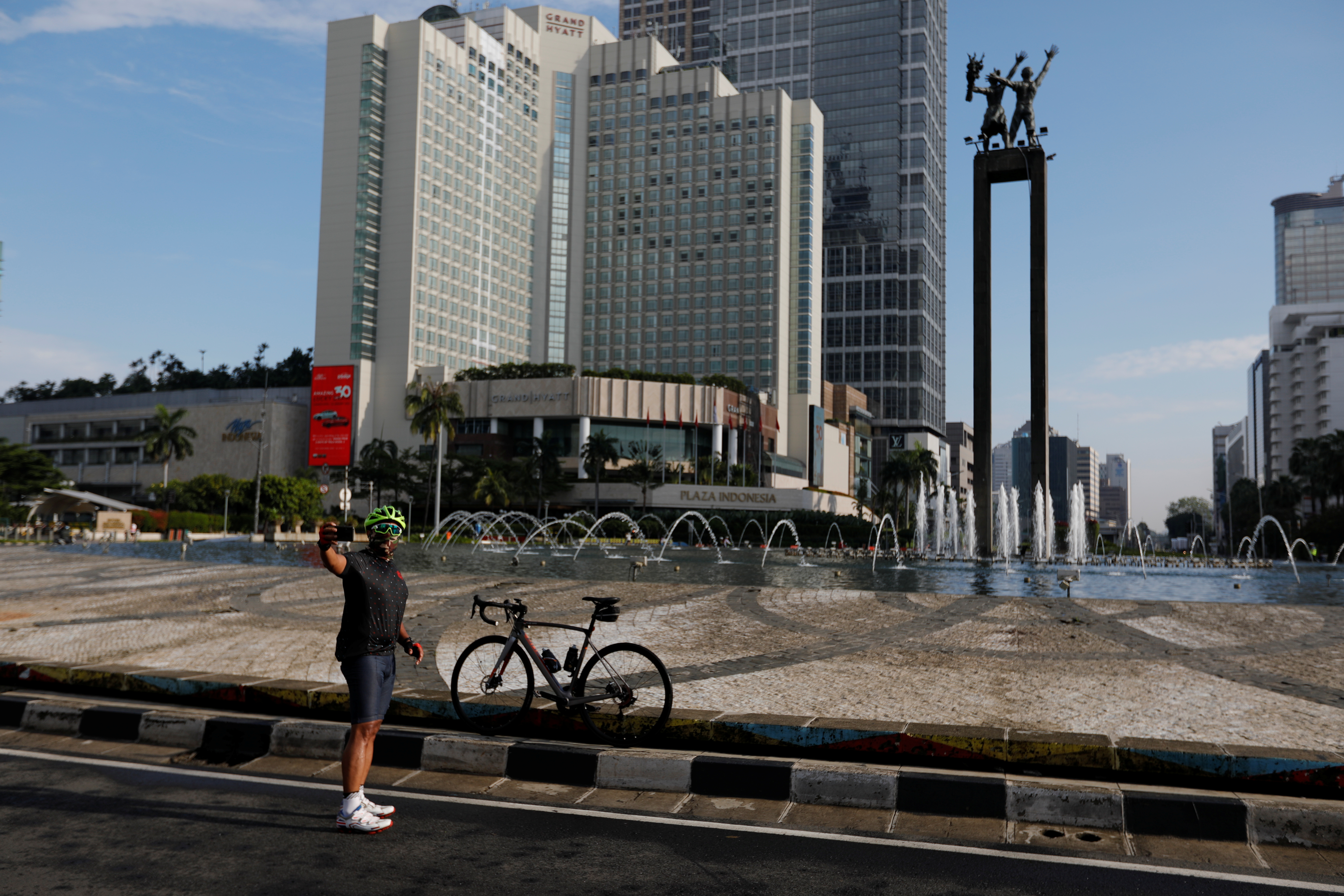 Una ciclista se toma una selfie frente a una fuente de aguas danzantes en Jakarta, Indonesia (REUTERS/Willy Kurniawan)