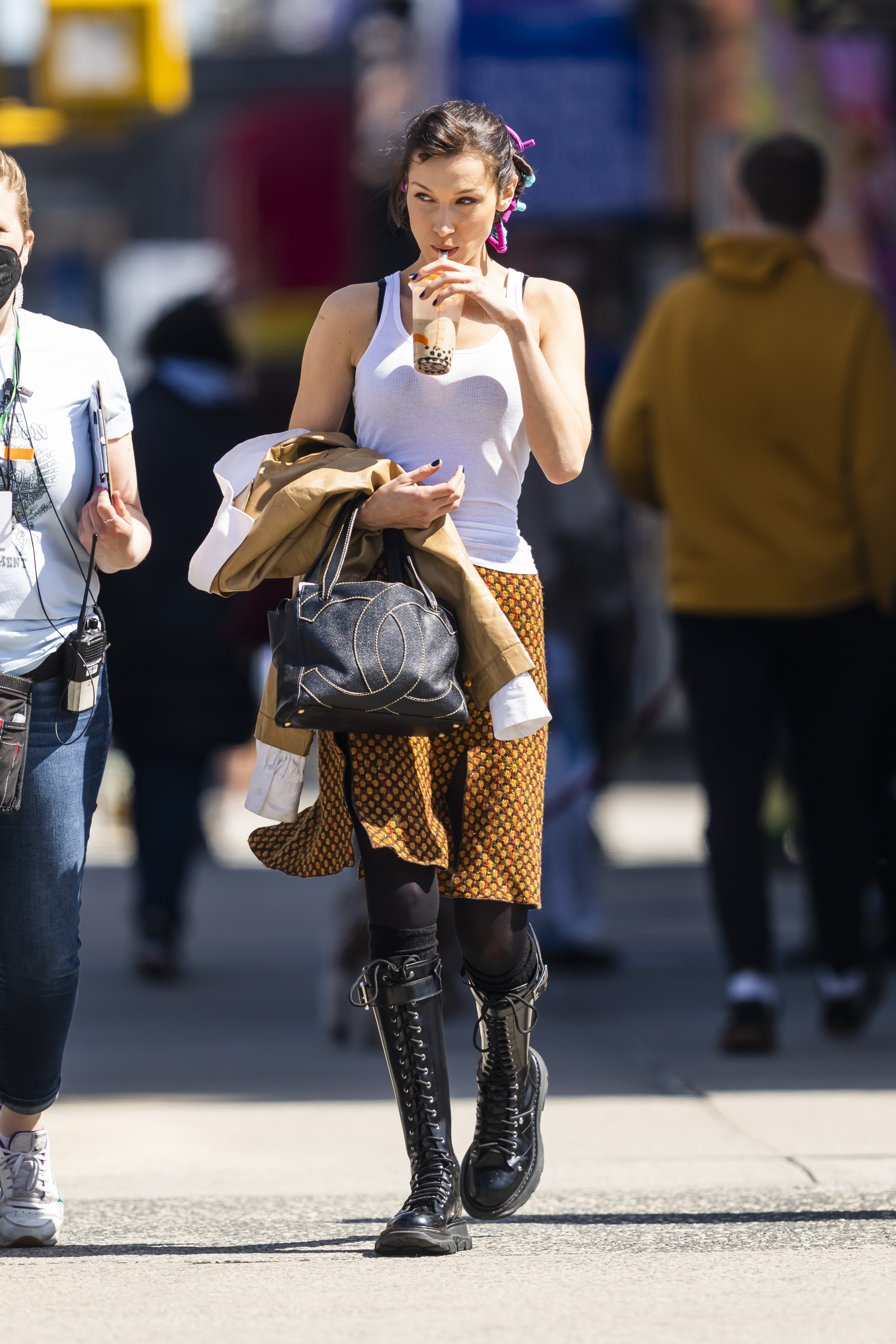 Bella Hadid fue fotografiada mientras caminaba por las calles de East Village, en Nueva York. Lució una pollera estampada, una musculosa básica blanca y una campera marrón. Llevó medias largas negras, borcegos de cuero que combinó con su cartera (Fotos: The Grosby Group)