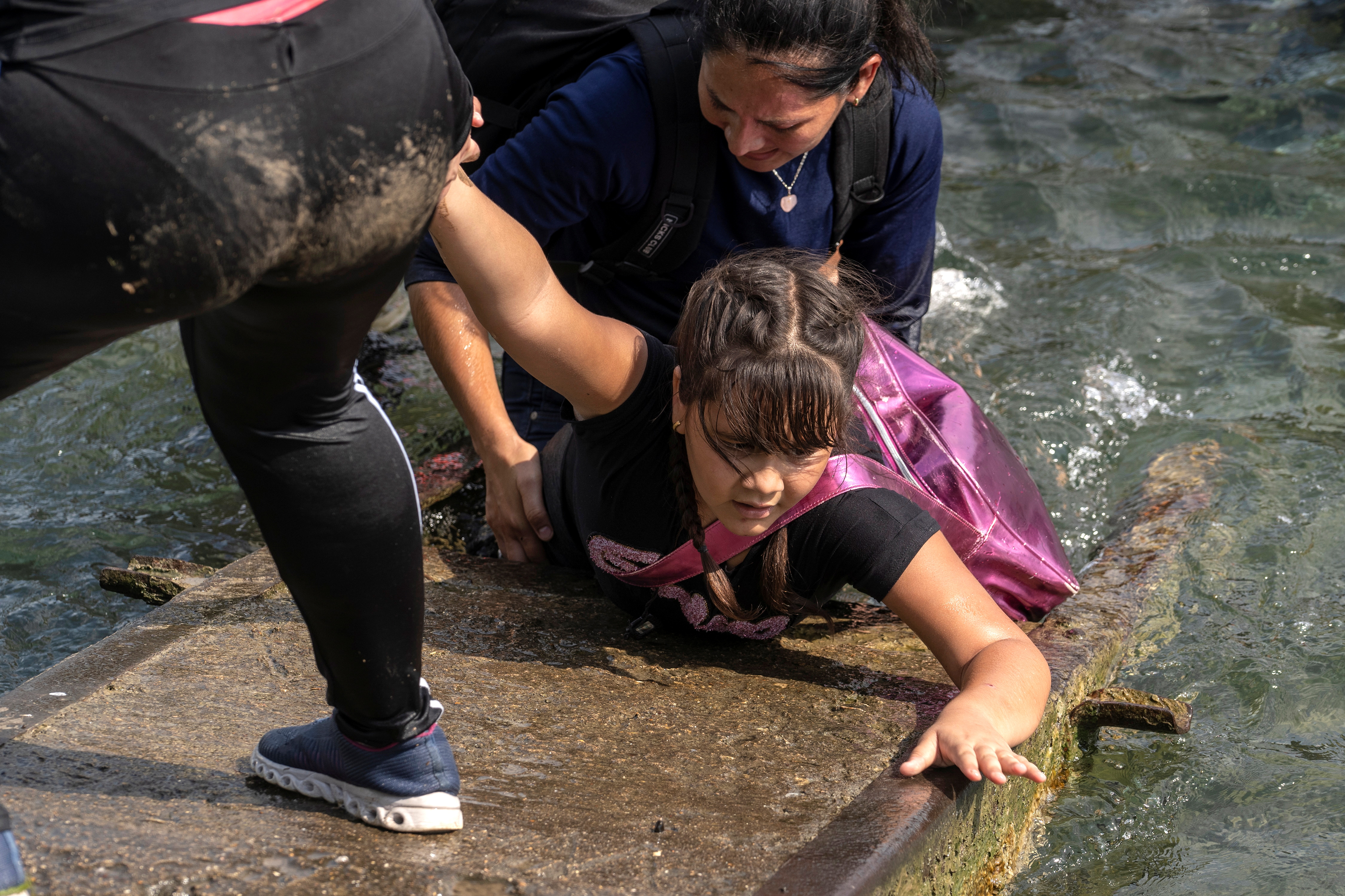 Personas ayudan a una niña venezolana a cruzar el río Grande hacia EEUU 
