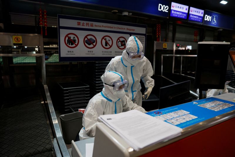 Personal de aerolínea con equipo de protección personal en el aeropuerto internacional de Pekín (REUTERS/Soe Zeya Tun/Archivo)