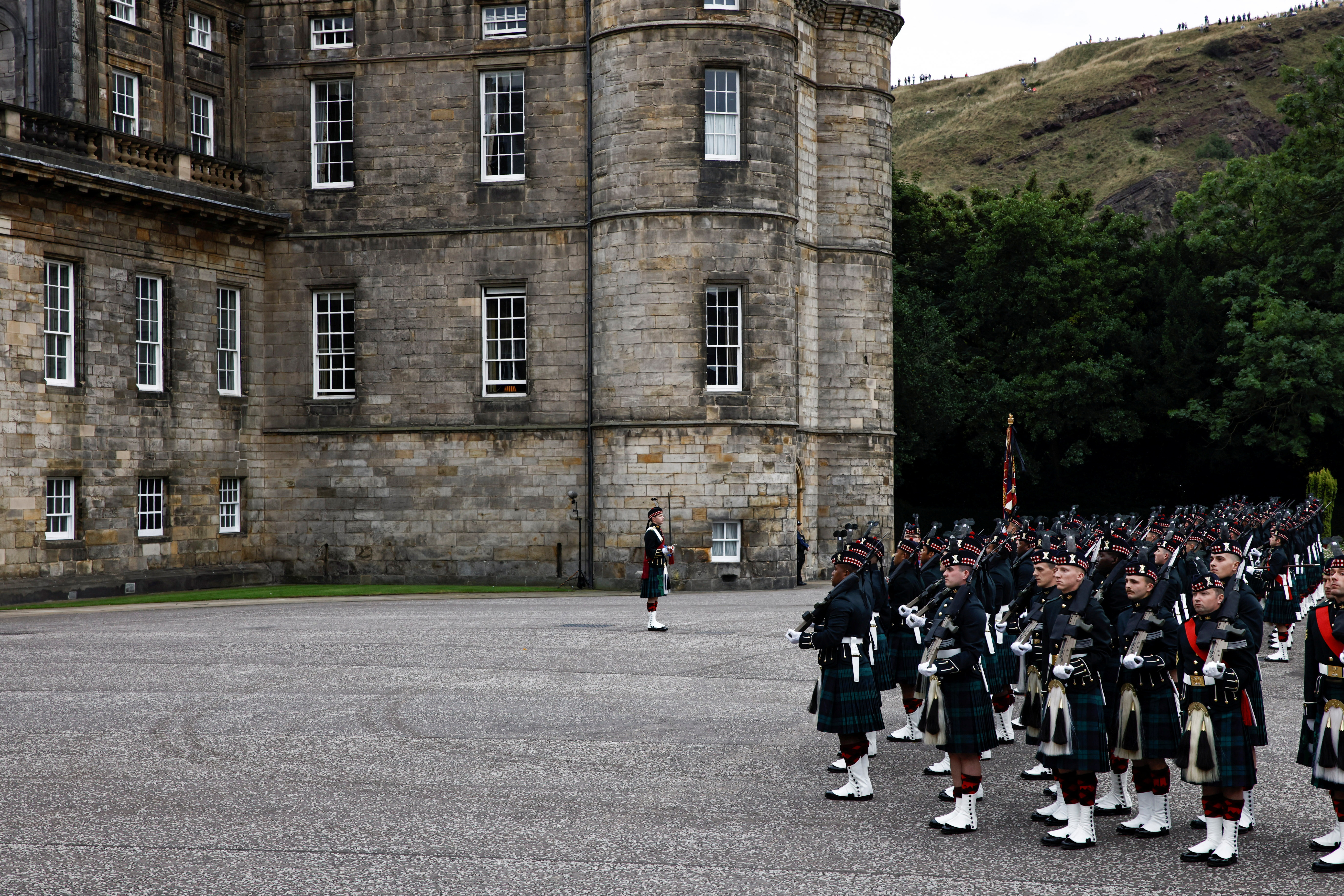 La guardia de honor se coloca en posición antes de que el coche fúnebre que lleva el ataúd de la reina Isabel de Gran Bretaña llegue al Palacio de Holyrood, en Edimburgo, Escocia, Gran Bretaña, el 11 de septiembre de 2022. (REUTERS/Alkis Konstantinidis)