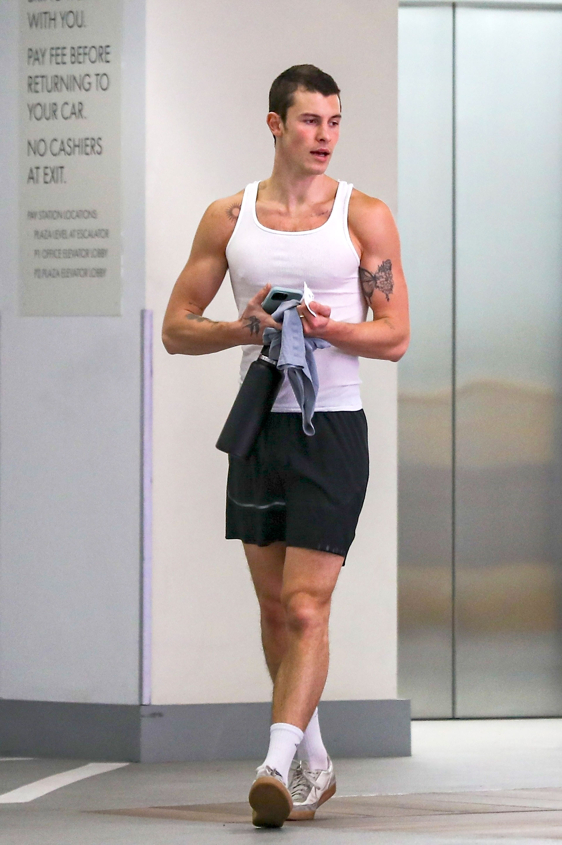 Shawn Mendes fue fotografiado cuando salía de un gimnasio privado de Los Ángeles. El artista llevaba ropa de entrenamiento: short negro, musculosa blanca, y cargaba una remera manga corta y una botella de agua