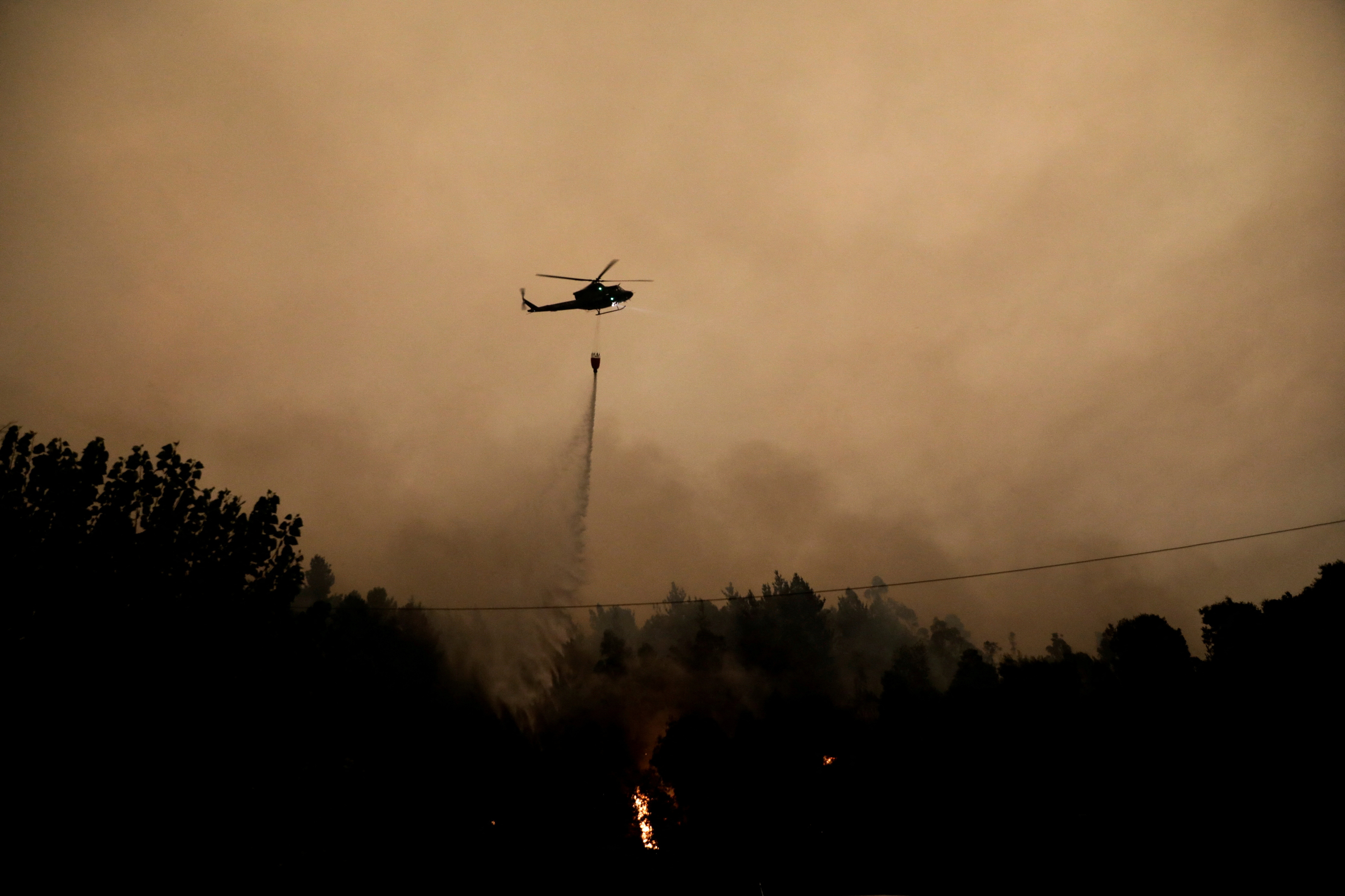 Un helicóptero asiste durante un incendio forestal en Santa Juana, cerca de Concepción, Chile, 3 de febrero de 2023. REUTERS/Juan Gonzalez 