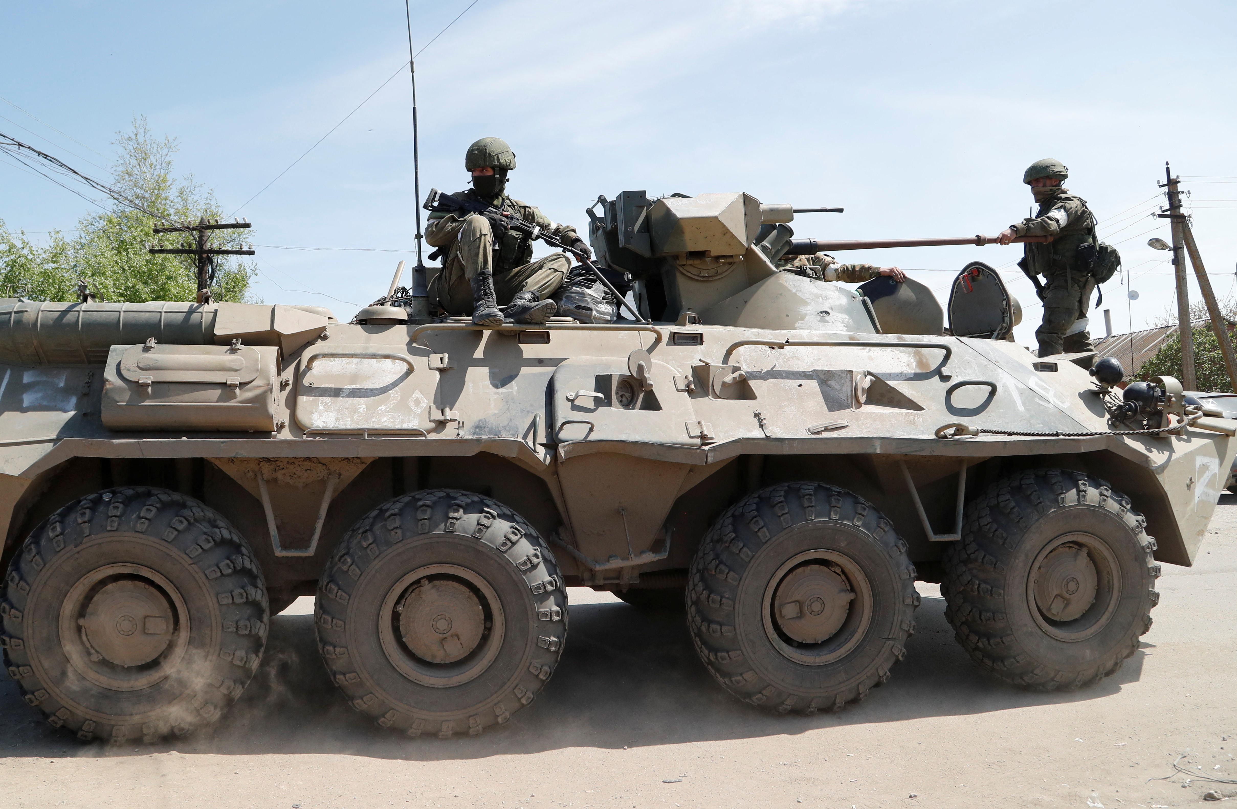 Service members of pro-Russian troops are seen atop of an armoured personnel carrier near a temporary accommodation centre for evacuees during Ukraine-Russia conflict in the village of Bezimenne in the Donetsk Region, Ukraine May 1, 2022. REUTERS/Alexander Ermochenko