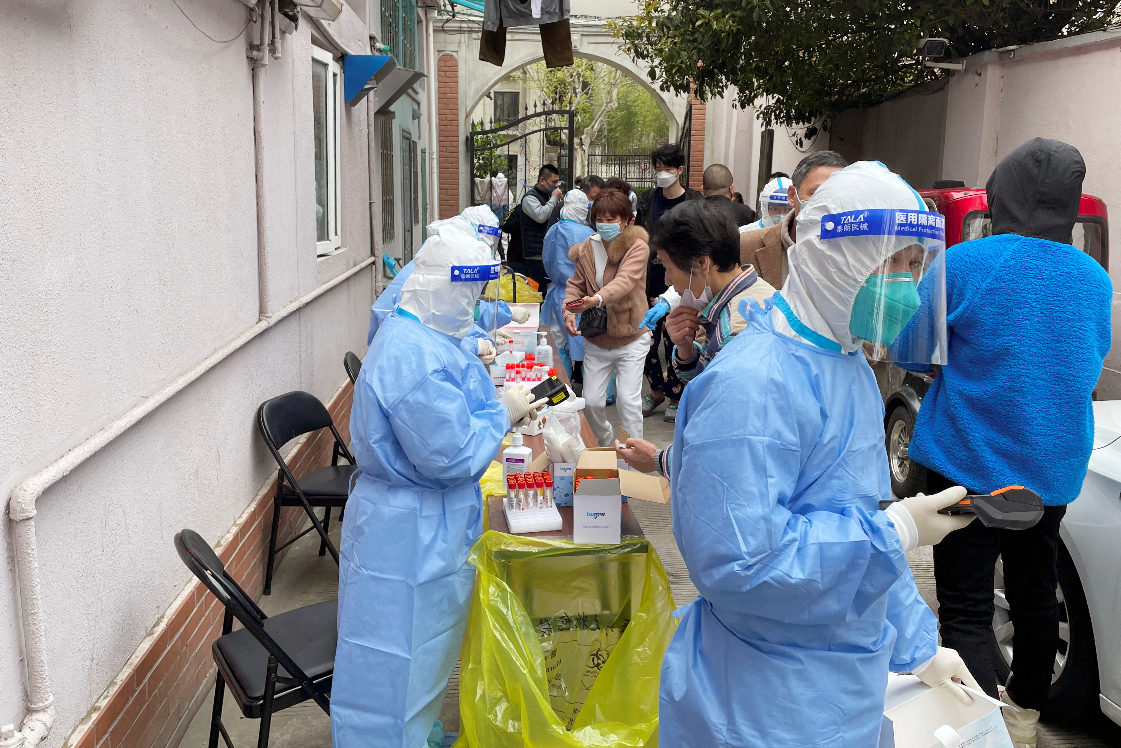 Los trabajadores médicos con trajes protectores administran testeos de PCR a los residentes en un complejo residencial, mientras comienza la segunda etapa de un bloqueo de dos etapas para frenar la propagación de la enfermedad por coronavirus (COVID-19) en Shanghái, China, el 1 de abril de 2022. REUTERS /Brenda Goh
