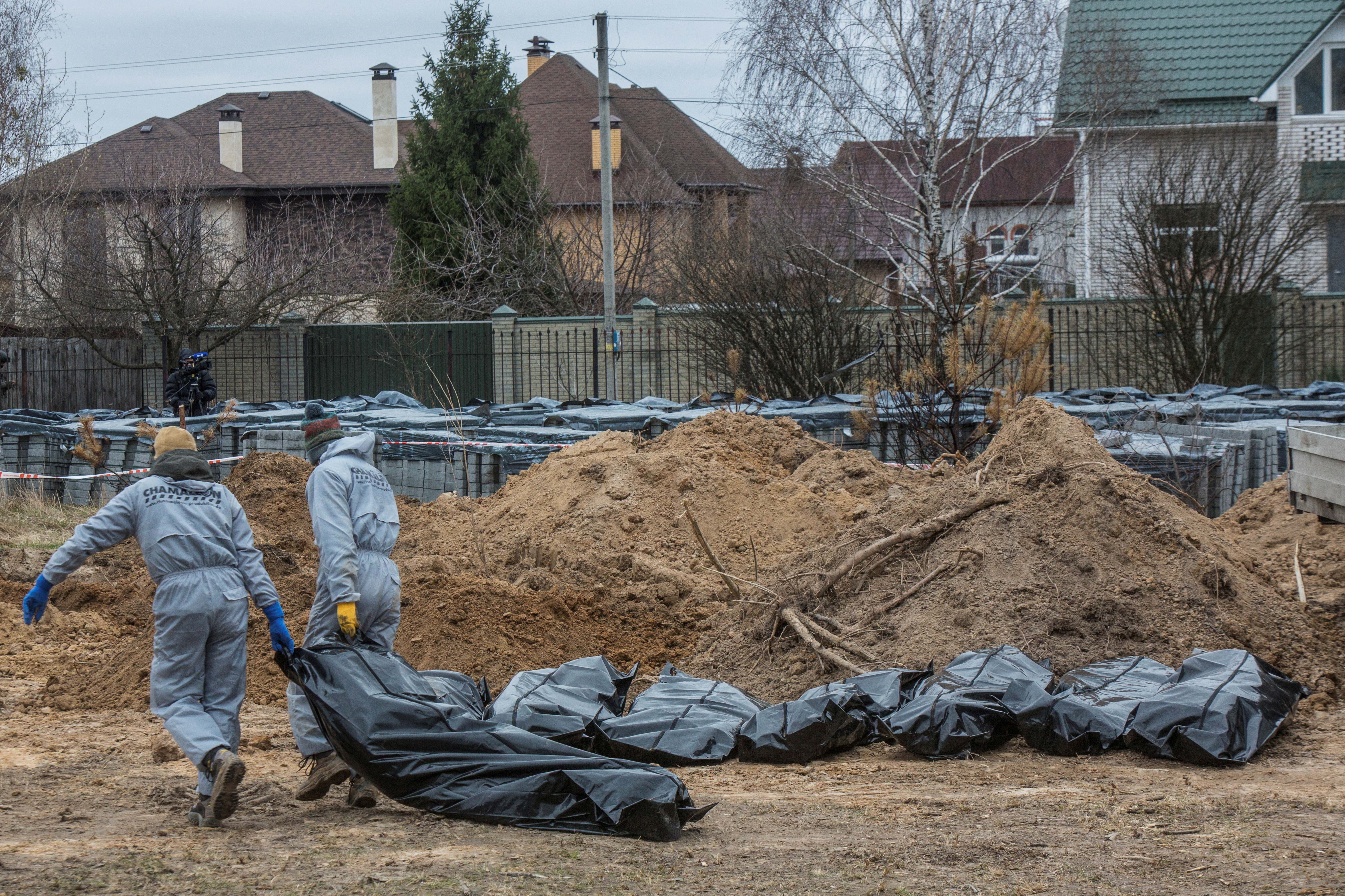 Técnicos forenses sacan el cuerpo de un civil asesinado durante la invasión rusa y luego enterrado y exhumado de una fosa común en la ciudad de Bucha, en las afueras de Kiev, Ucrania, el 13 de abril de 2022. REUTERS/Volodymyr Petrov