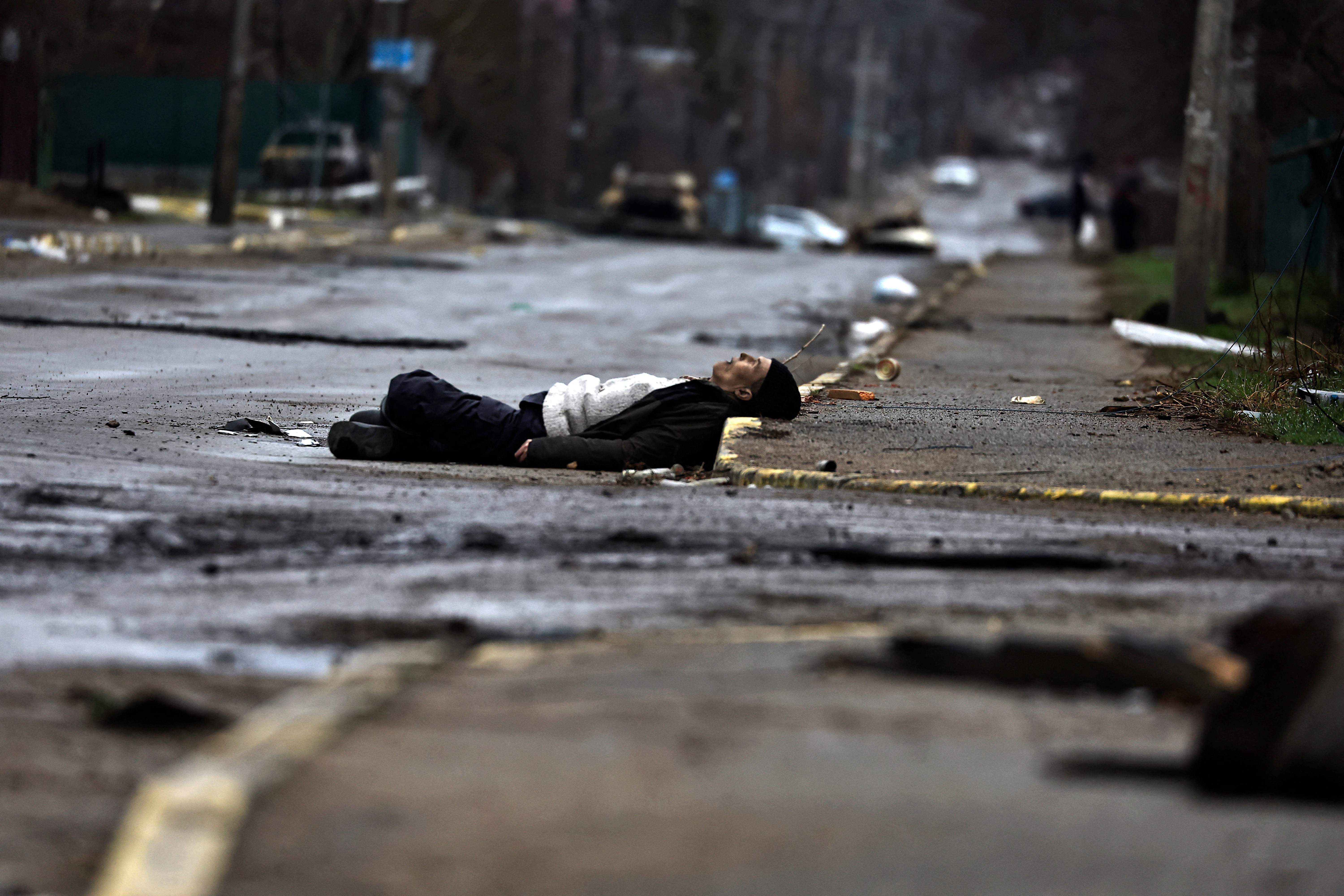 Ciało cywila zastrzelonego przez żołnierzy armii rosyjskiej leżące na ulicy podczas rosyjskiej inwazji na Ukrainę w Buczy, kilka kilometrów od Kijowa (Reuters)