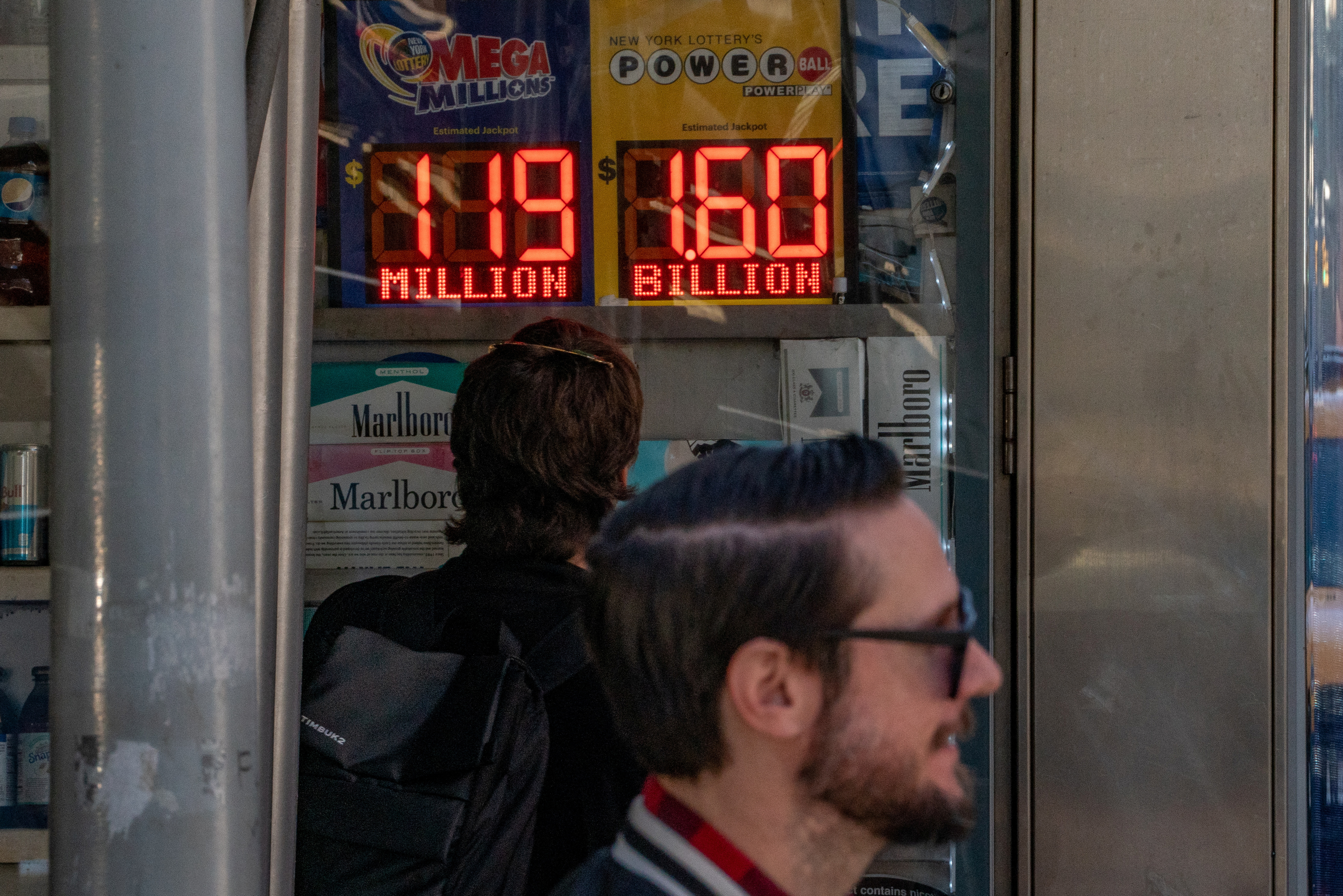 A person looks at a digital billboard announcing the $1.6 billion Powerball jackpot in New York City