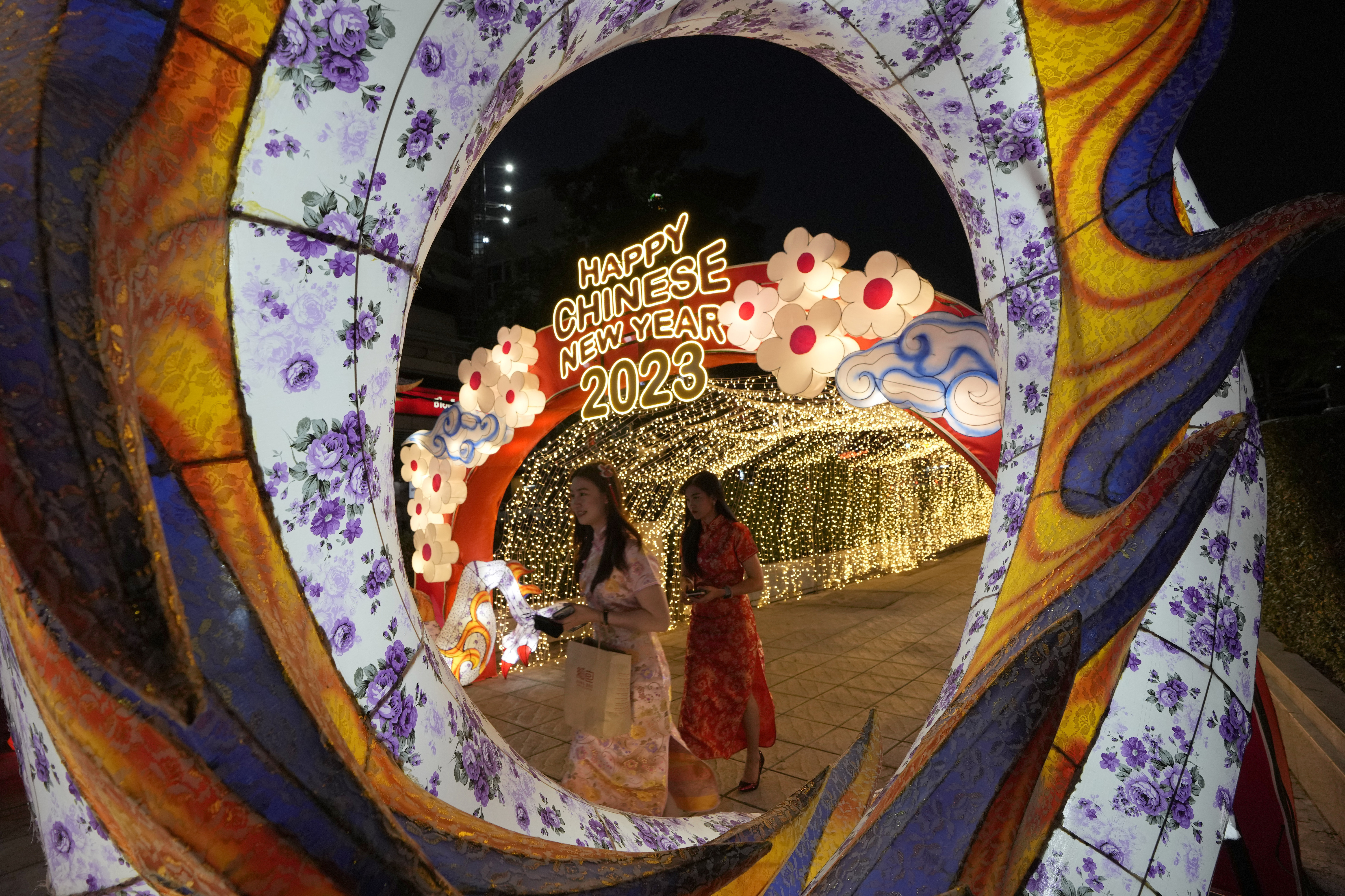 Two women walk past Lunar New Year decorations in Bangkok, Thailand, Thursday, Jan. 19, 2023. The turn of the year is celebrated on Jan. 22, kicking off the Year of the Rabbit, according to the lunar calendar.  (AP Photo/Sakchai Lalit)
