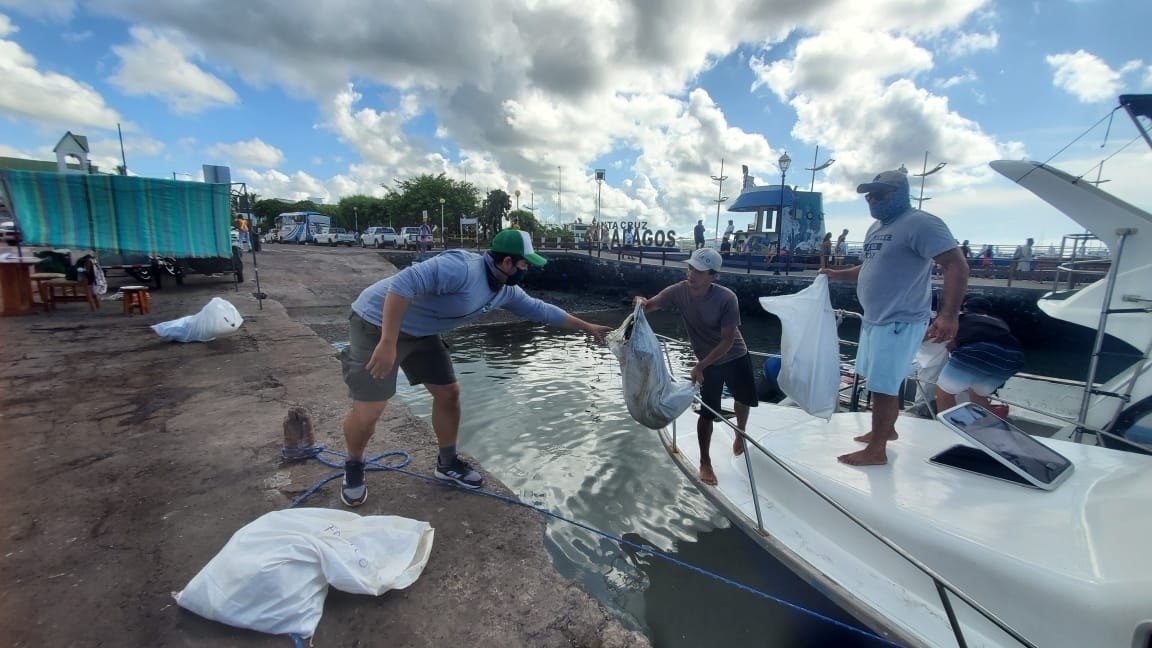 Foto de archivo: Hombres descargan bolsas con basura recogida del mar durante una jornada de limpieza ecológica en Islas Galápagos (Ecuador) (EFE/ Ministerio del Ambiente y Agua de Ecuador)