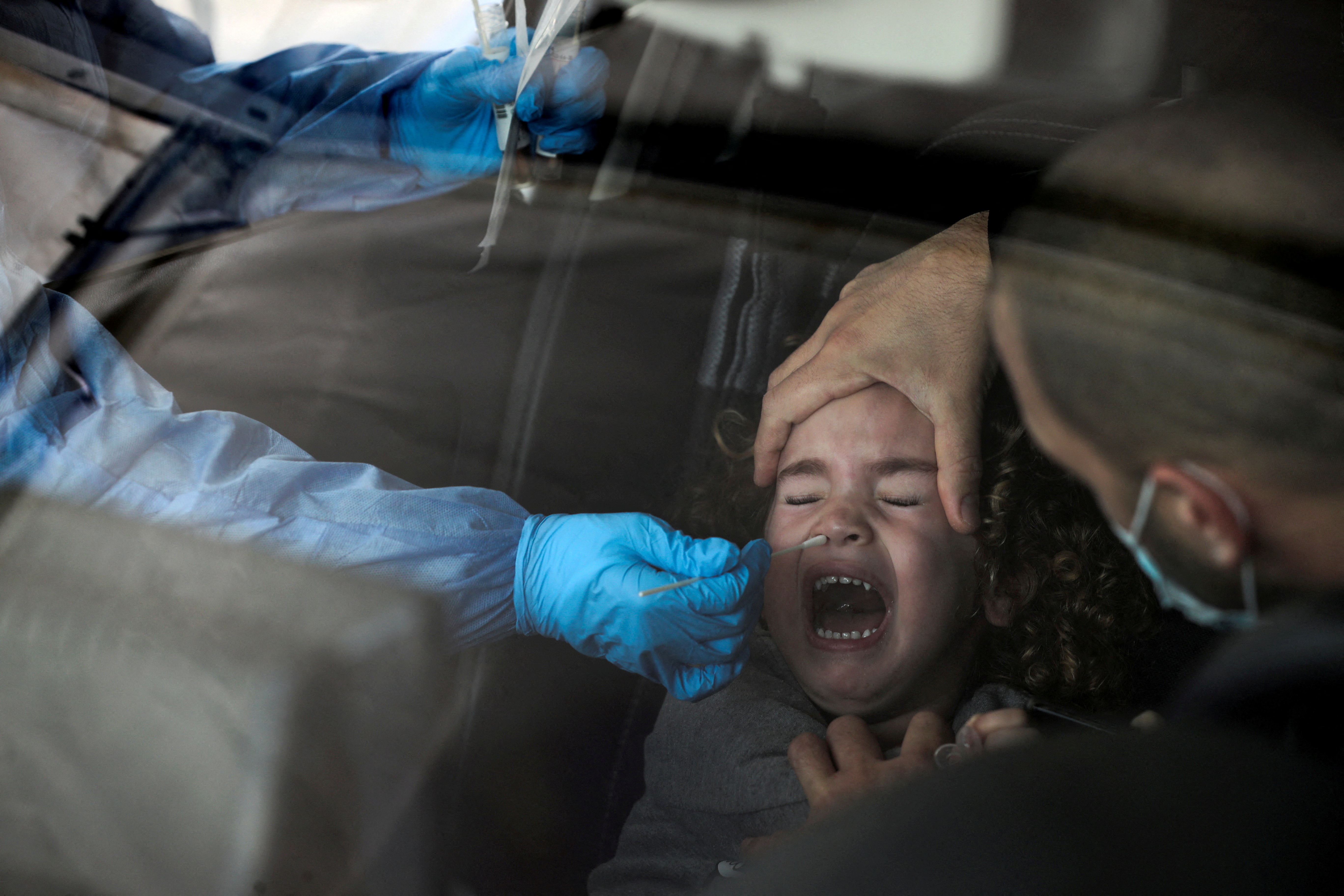 FOTO DE ARCHIVO: Una niña es examinada para detectar la enfermedad del coronavirus (COVID-19) en un lugar de paso mientras Israel enfrenta un aumento en las infecciones de la variante Omicron, en Jerusalén el 3 de enero de 2022. REUTERS / Ammar Awad / File Photo