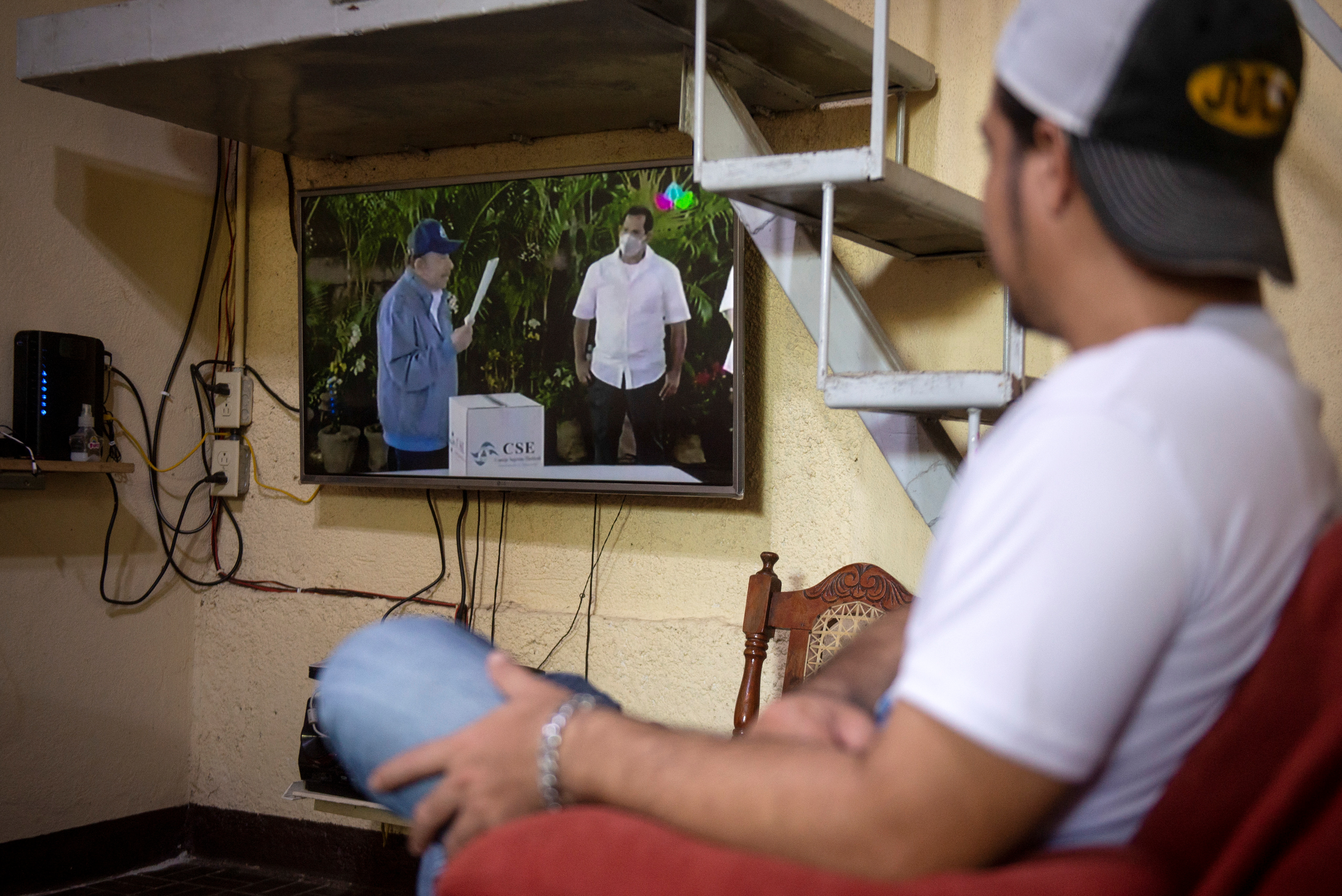 Un ciudadano nicaragüense observa desde su casa el momento en que Daniel Ortega y su esposa, Rosario Murillo, llegan a depositar su voto. (Foto Reuters)  