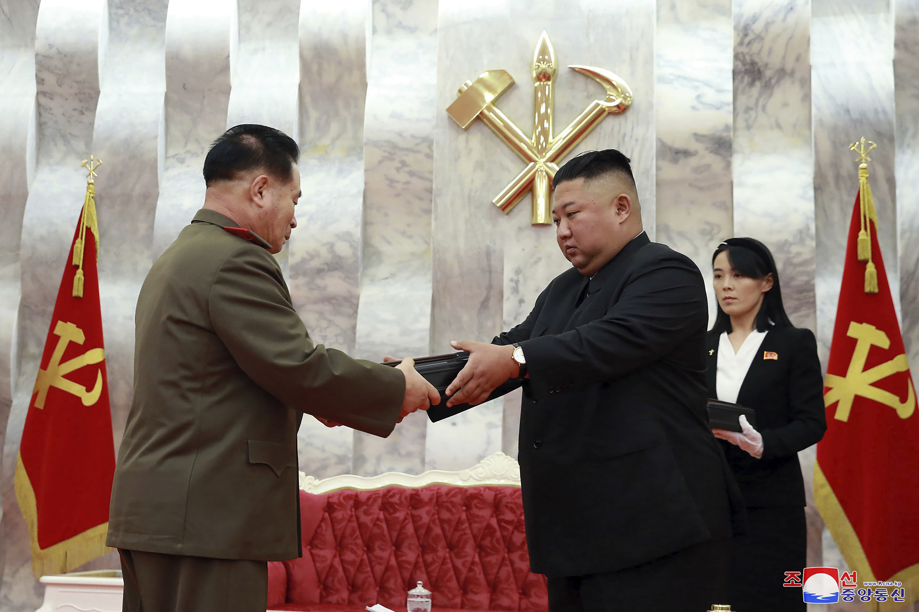 En esta imagen del domingo 26 de julio de 2020, el líder de Corea del Norte, Kim Jong Un, entrega una pistola conmemorativa a un oficial del Ejército durante una ceremonia en Pyongyang, Corea del Norte. A la derecha se ve la influyente hermana de Kim, Kim Yo Jong. (Agencia Central de Noticias de Corea/Servicio de Noticias de Corea via AP)