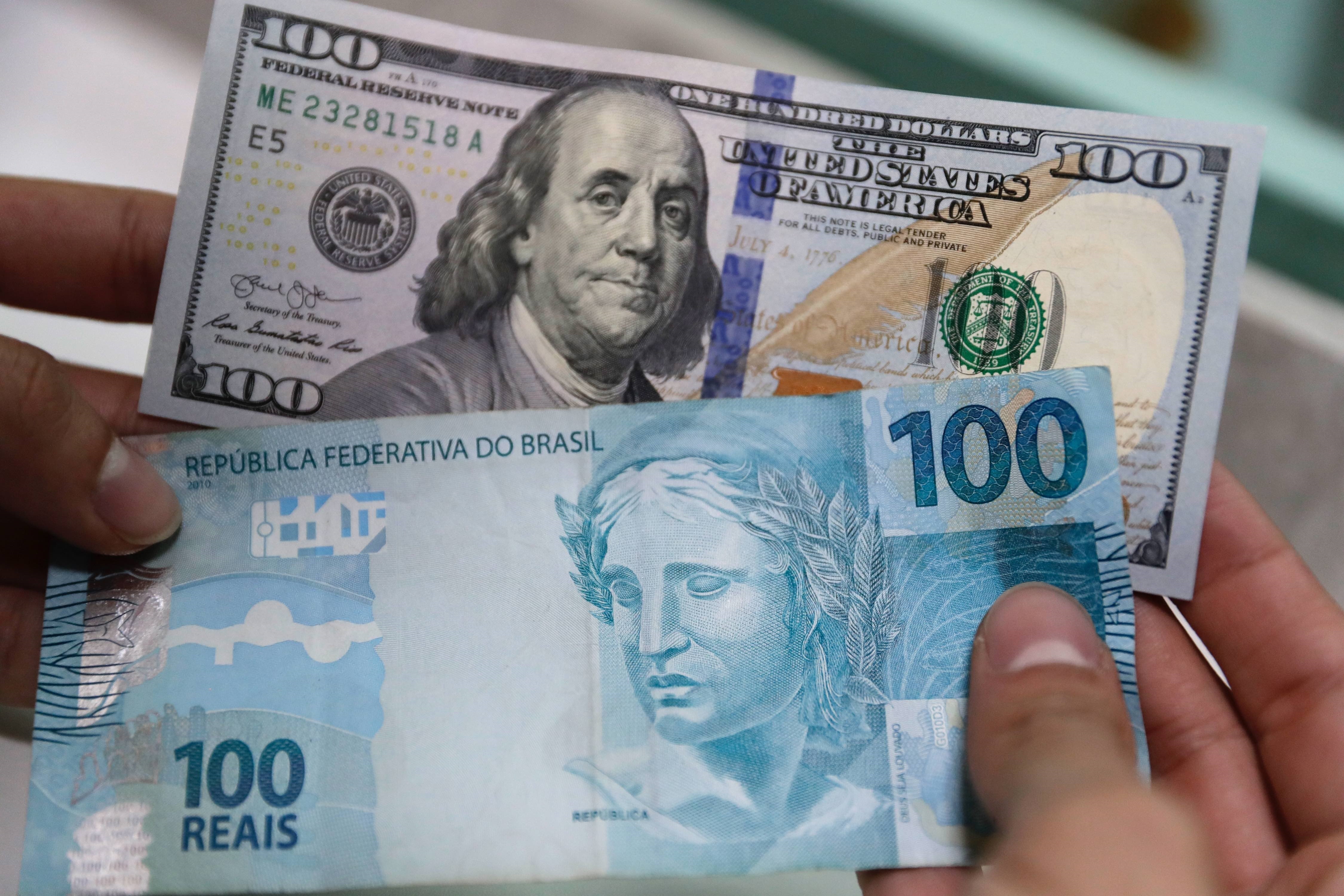 Foto de archivo de un billete de 100 dólares y un billete de 100 reales en San Pablo, Brasil (EFE/Fernando Bizerra Jr.)