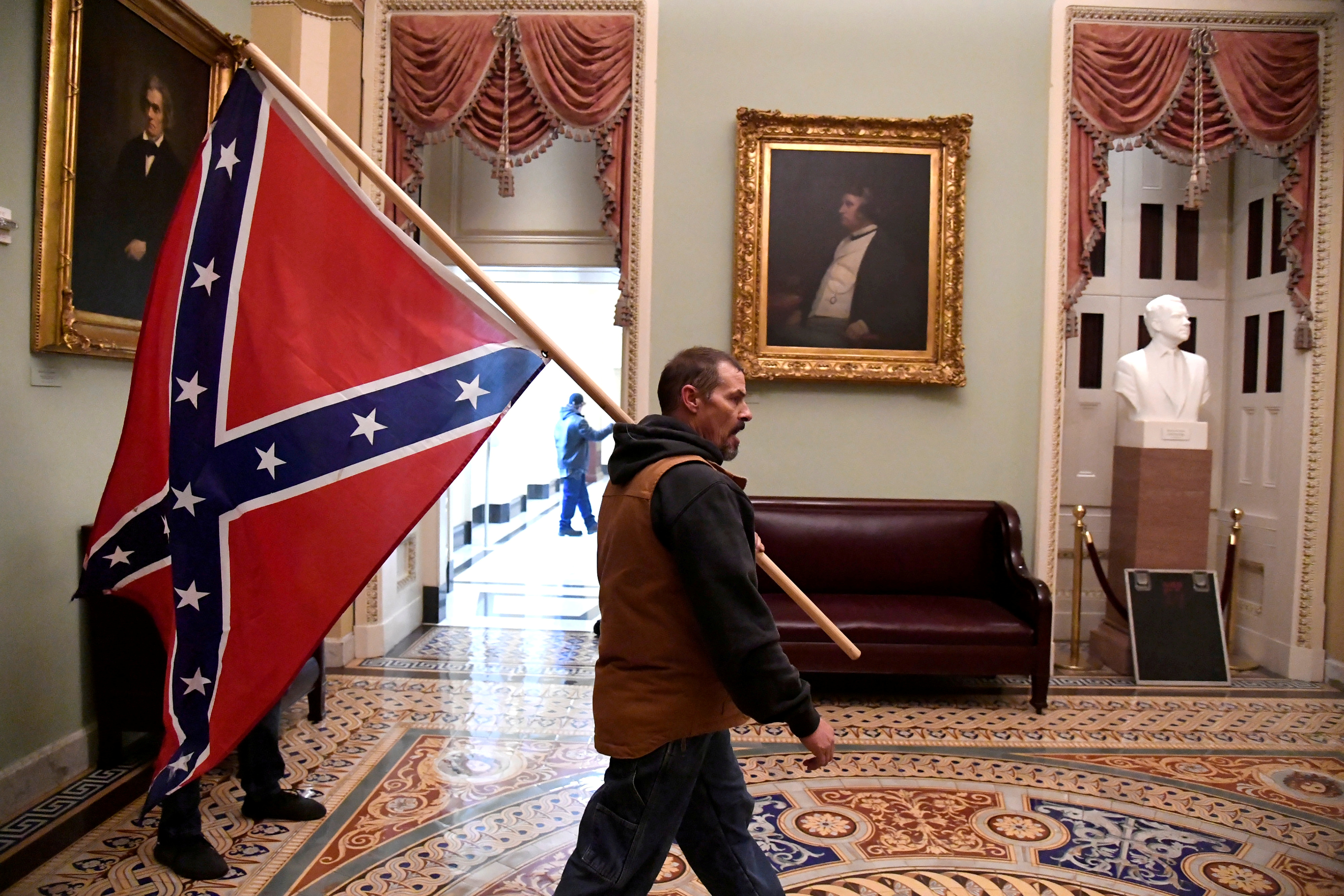 Un activista con la bandera confederada camina por los pasillos internos del Capitolio. El plan era impedir a cualquier precio que Joe Biden sea certificado como nuevo presidente norteamericano. No lo lograron y el Capitolio impuso su legalidad (Reuters)