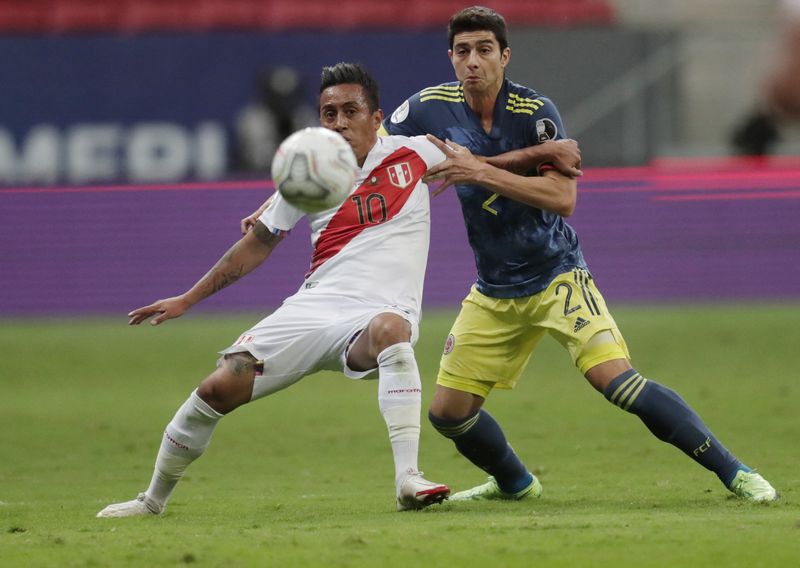 El peruano Christian Cueva aguantando la marca del colombiano Stefan Medina en un partido de la Copa América 2021. | Foto: REUTERS