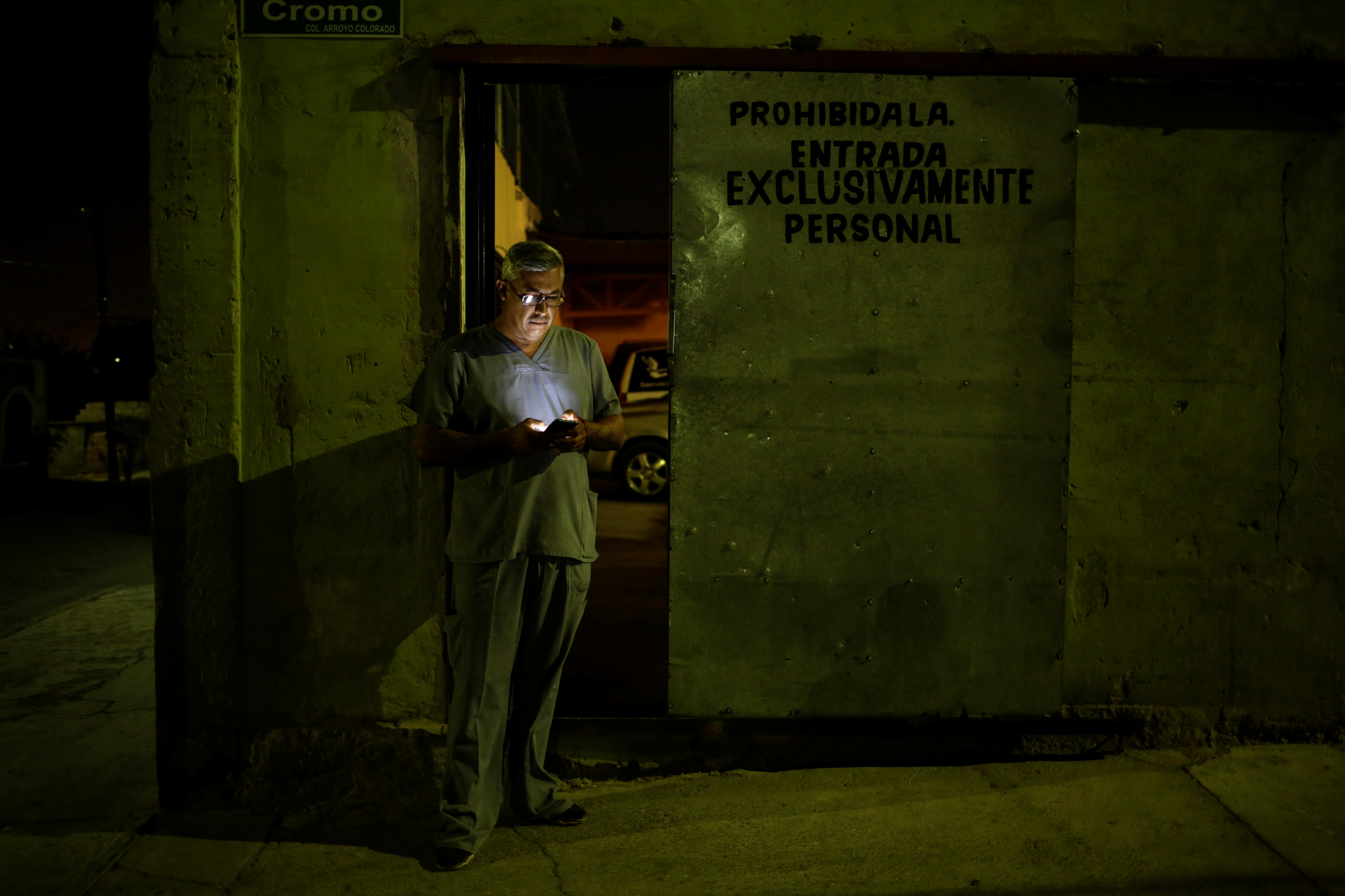 Un empleado de la funeraria Ríos revisa su teléfono fuera de la funeraria, mientras continúa el brote del coronavirus (COVID-19), en Ciudad Juárez, México, el 23 de octubre de 2020.