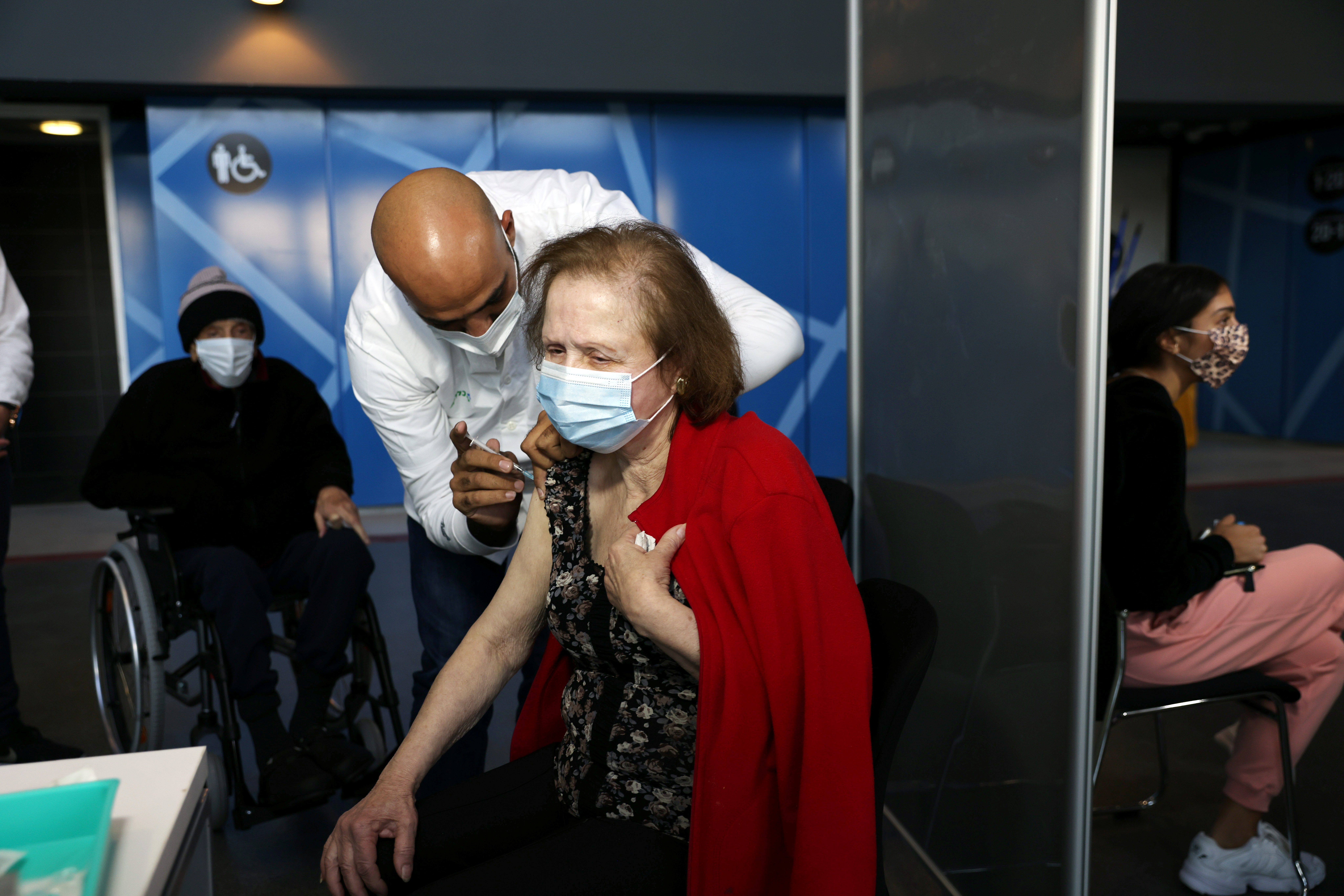 Una mujer recibe una vacuna contra la enfermedad del coronavirus (COVID-19) en un centro de vacunación en Jerusalén, el 3 de enero de 2021 (Reuters)