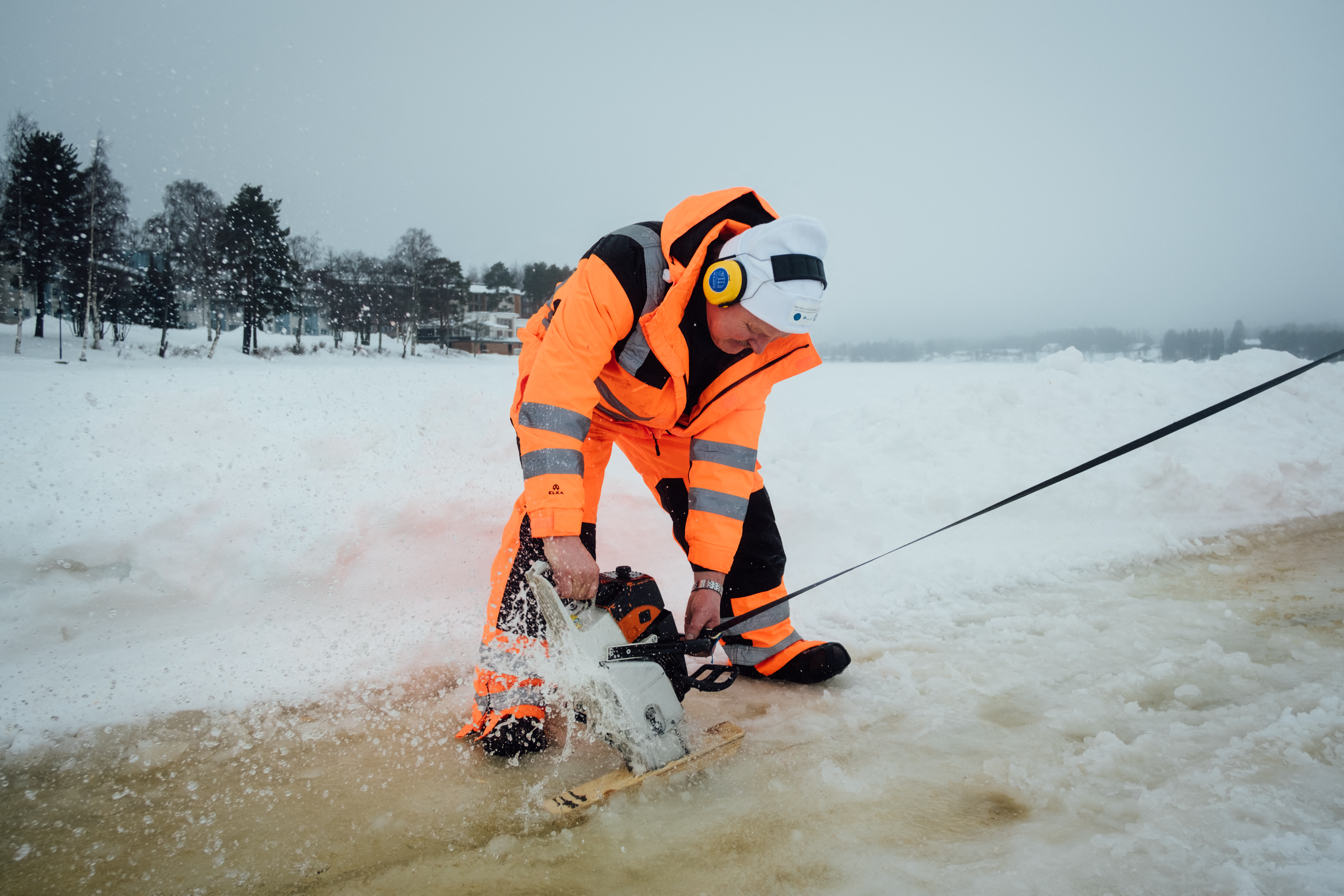Un hombre usa una motosierra para cortar a lo largo del perímetro de un carrusel de hielo (Alessandro RAMPAZZO / AFP)