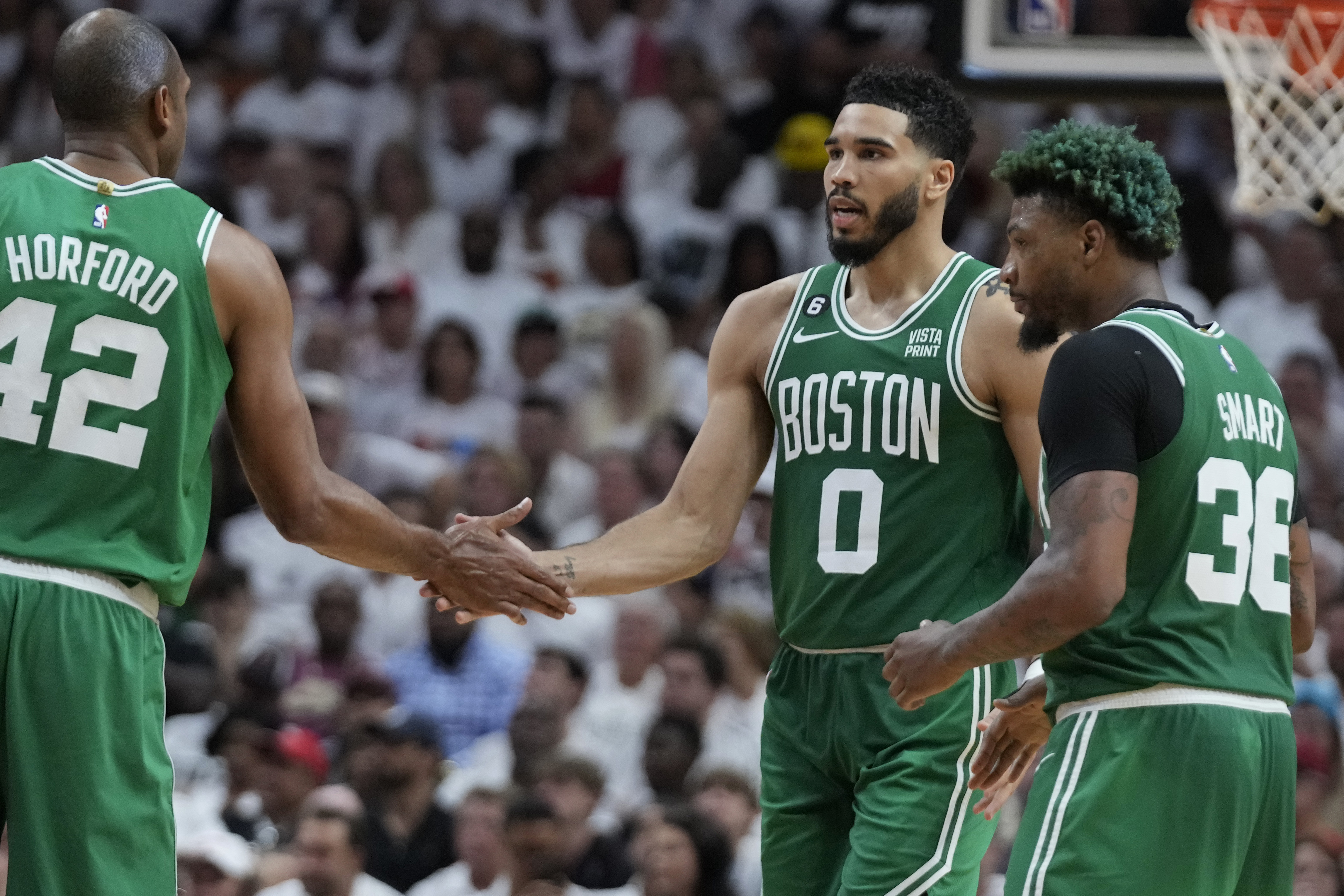 Jayson Tatum estrecha la mano del dominicano Al Horford, su compañero en los Celtics de Boston, durante la victoria sobre el Heat de Miami, el martes 23 de mayo de 2023 (AP Foto/Wilfredo Lee)