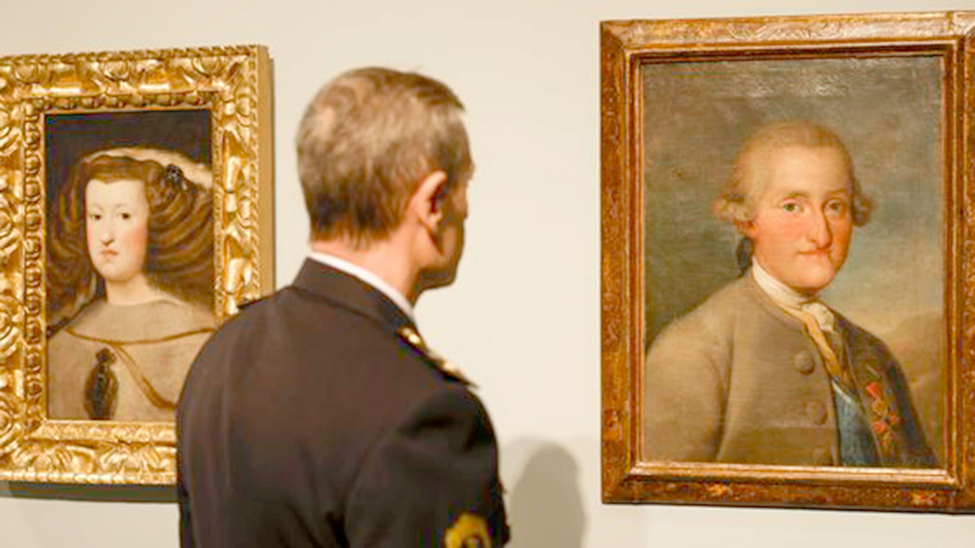 Un agente de la Unidad de Patrimonio de la Policía de la Generalitat contemplando algunos de los cuadros falsificados. (EFE/Biel Aliño)