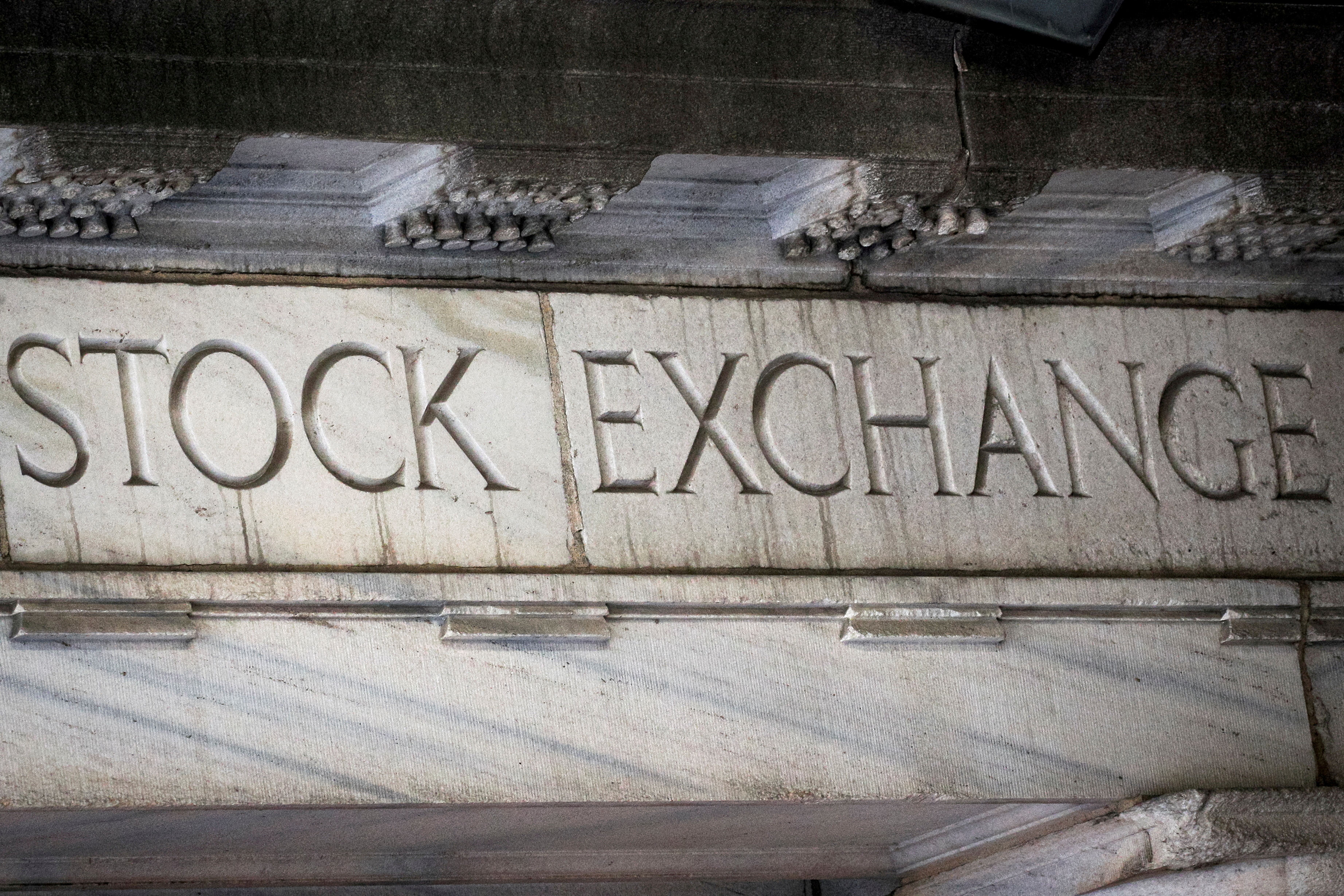 FILE PHOTO: "Stock Exchange" is seen over an entrance to the New York Stock Exchange (NYSE) on Wall St. in New York City, U.S., March 29, 2021.  REUTERS/Brendan McDermid/File Photo