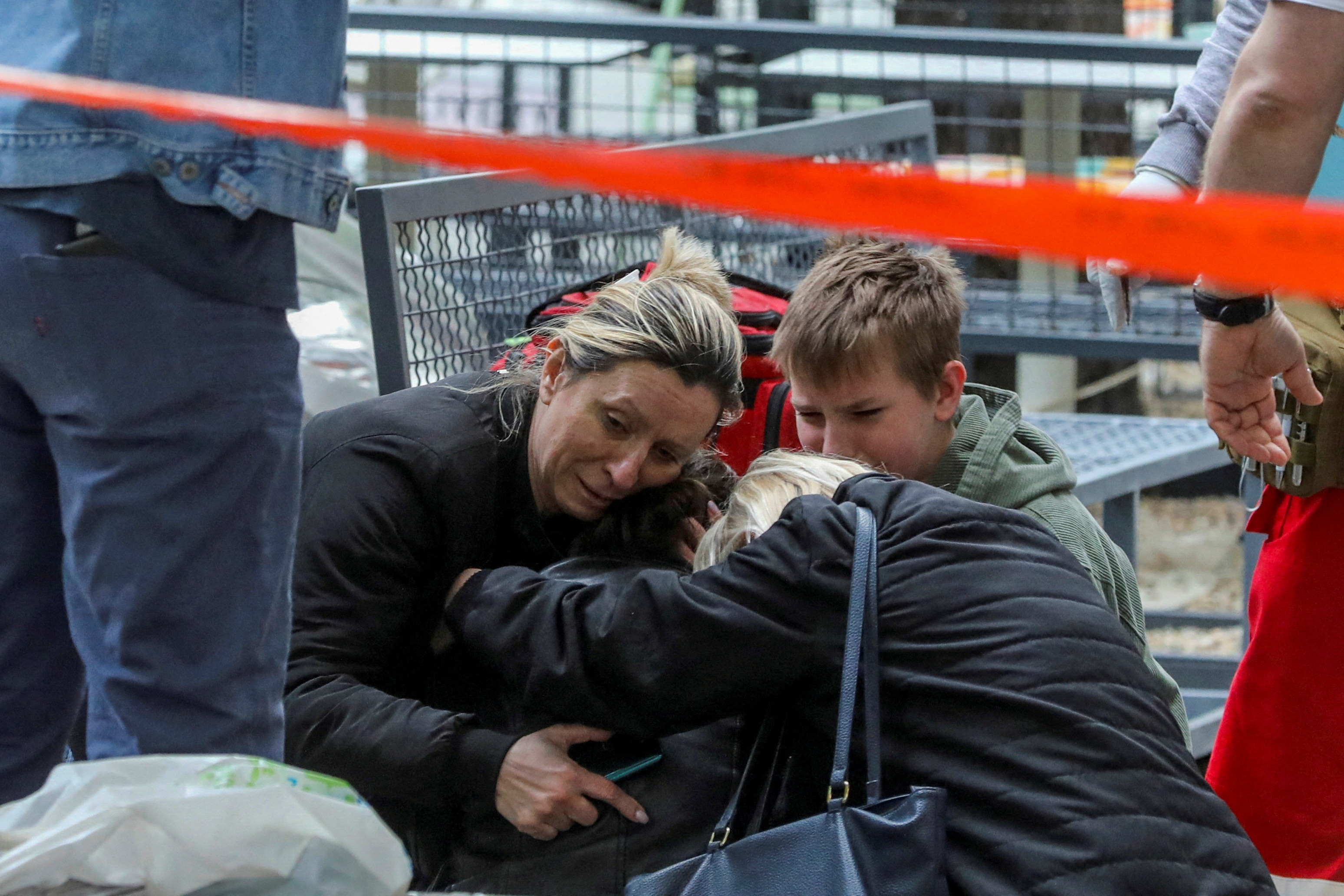 Parientes de una de las víctimas se abrazan frente a la escuela (REUTERS/Djordje Kojadinovic)