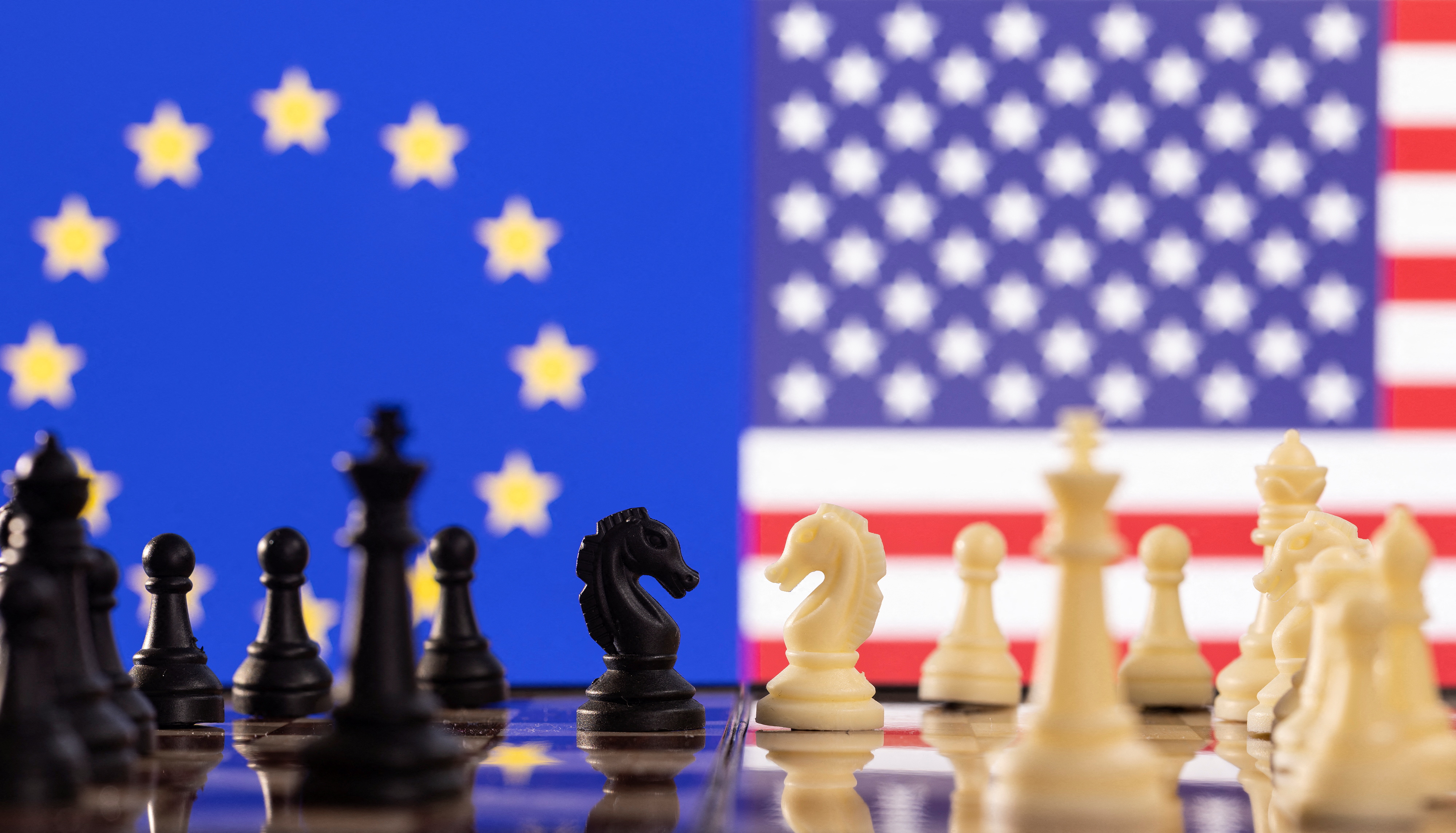 Chess pieces are seen in front of displayed U.S. and EU flags in this illustration taken January 25, 2022. REUTERS/Dado Ruvic/Illustration