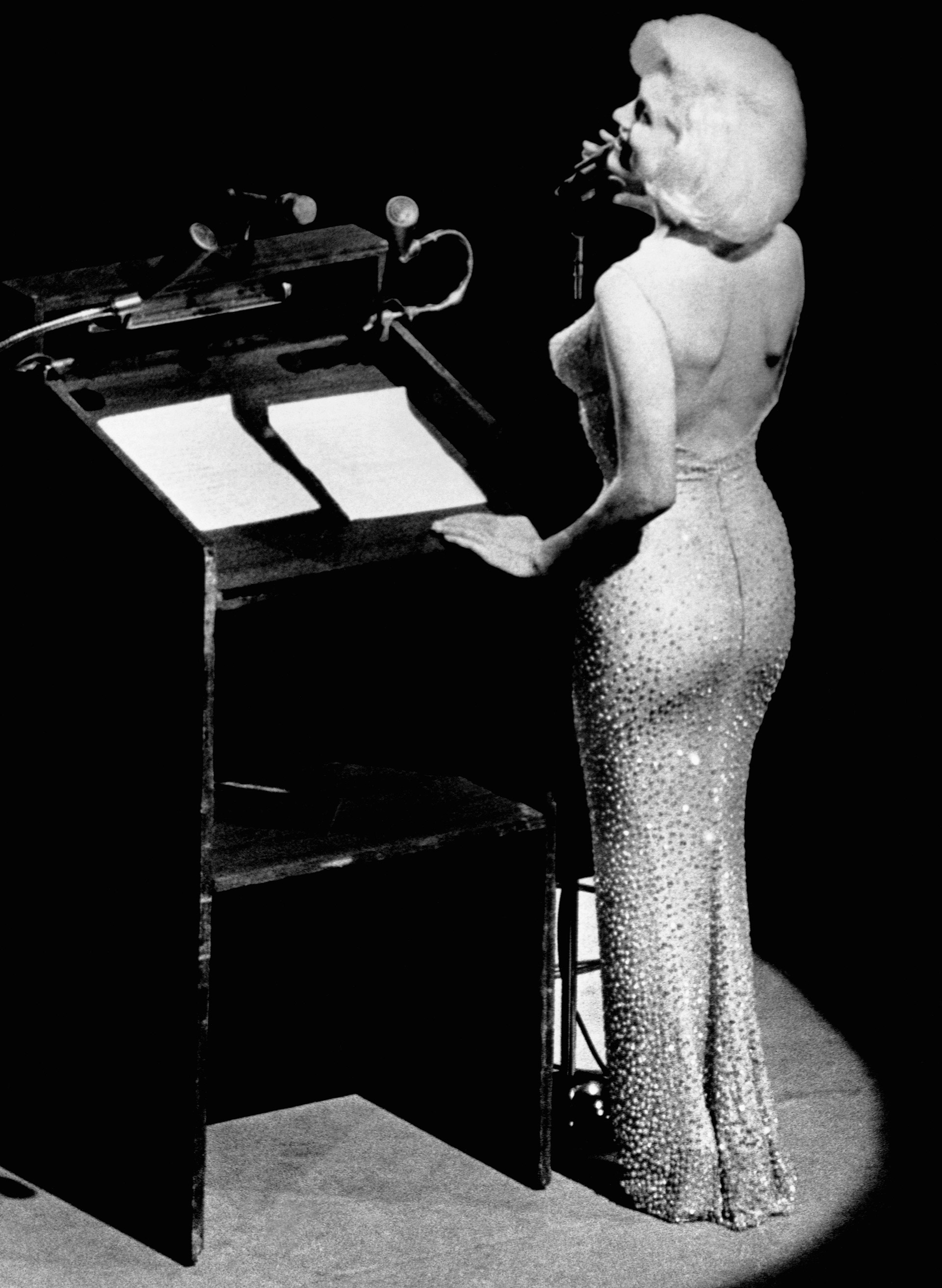 El impactante vestido que llevó Marilyn esa noche era tan ceñido que se lo cosieron puesto. Fue un diseño del francés Jean Louis Berthault, tenía 2.500 cristales, era de color piel y la actriz pagó por él 12 mil dólares