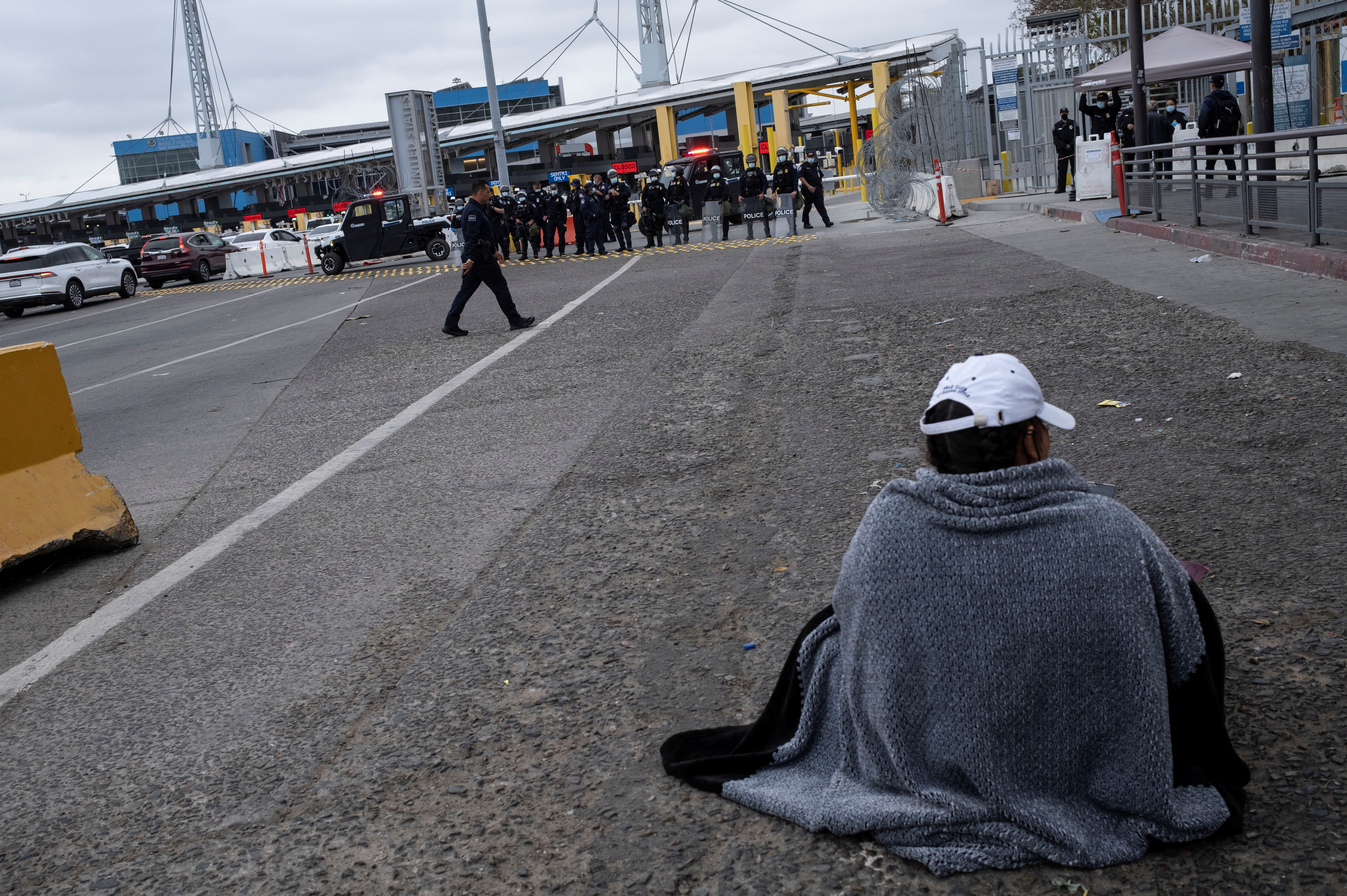 Un migrante que busca solicitar asilo se sienta cerca a la frontera con mEEUU, en Tijuana (Reuters)