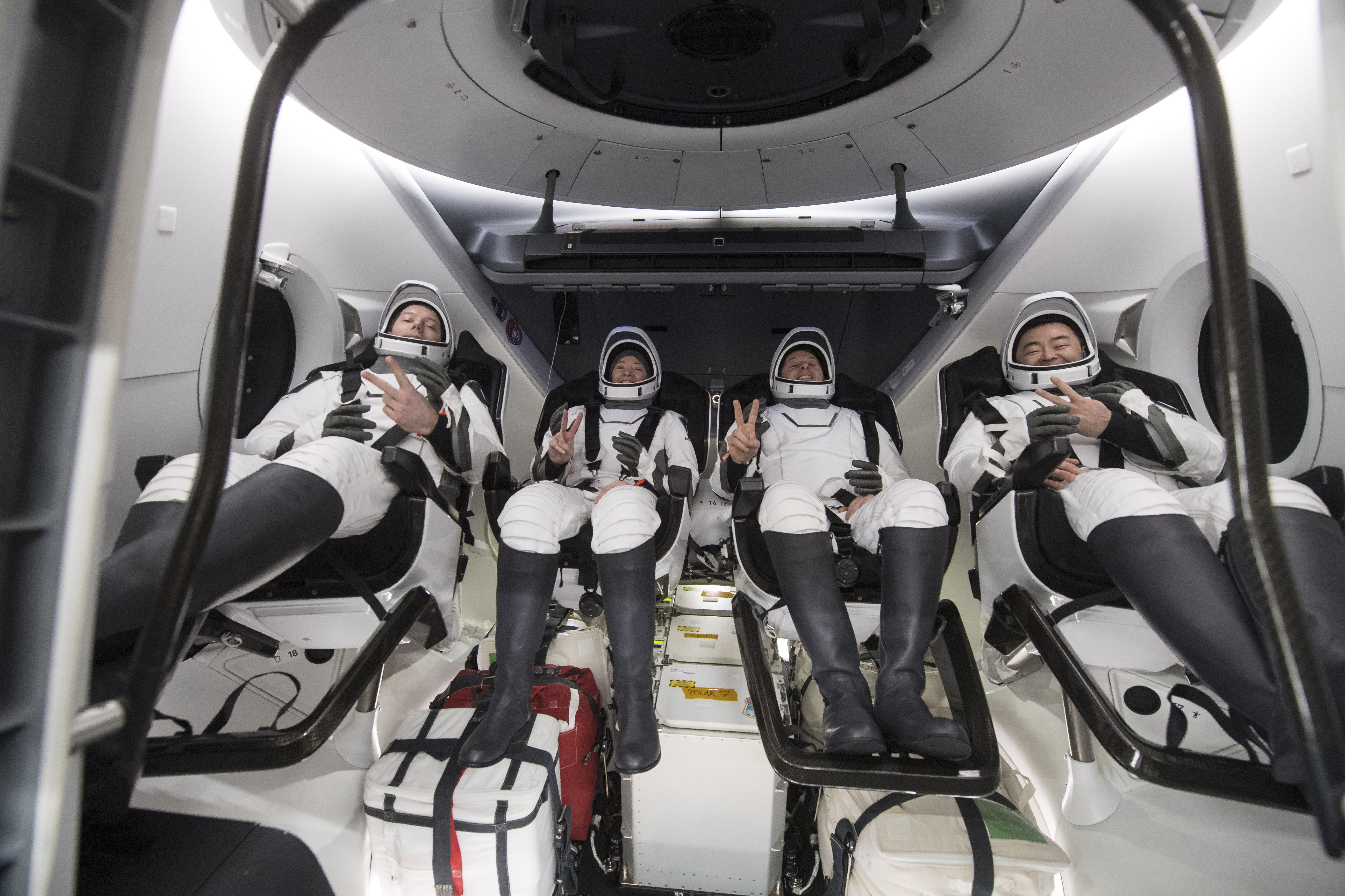 In this photo provided by NASA, from left to right, European Space Agency astronaut Thomas Pesquet, NASA astronauts Megan McArthur and Shane Kimbrough, and Japan Aerospace Exploration Agency astronaut Akihiko Hoshide gesture inside the SpaceX Dragon spacecraft onboard the SpaceX GO Navigator recovery ship shortly after having landed in the Gulf of Mexico off the coast of Pensacola, Fla., Monday, Nov. 8, 2021. The astronauts returned to Earth on Monday to end a 200-day space station mission that began last spring. (Aubrey Gemignani/NASA via AP)