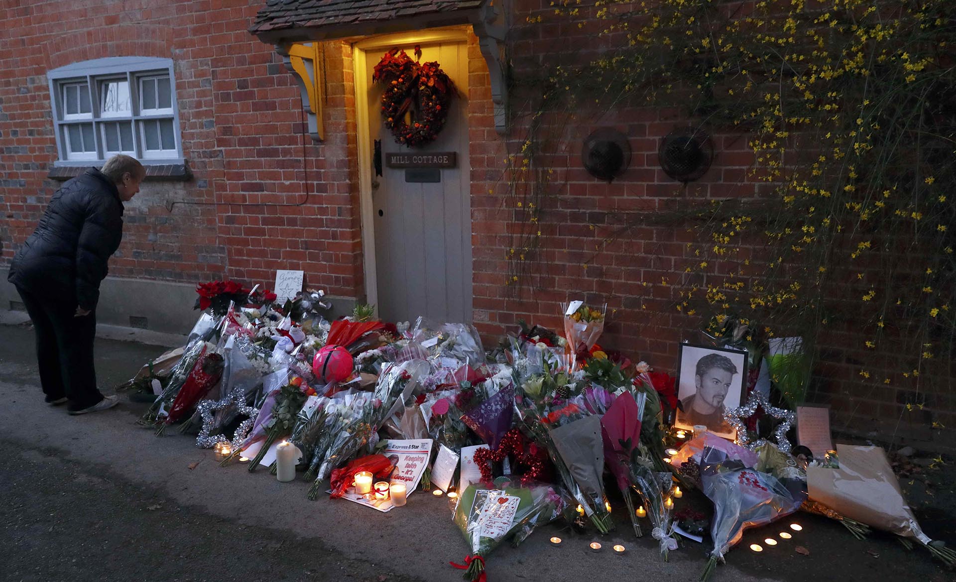 Una mujer mira los tributos que los fans dejaron en la casa de George Michael al día siguiente de su muerte  REUTERS/Eddie Keogh