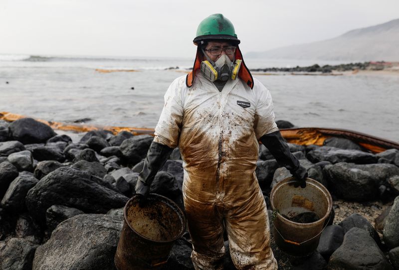 FOTO DE ARCHIVO: Un trabajador trabaja en la limpieza de crudo de petróleo de una playa tras el derrame originado en la refinería La Pampilla de la empresa española Repsol en la costa de Lima, en el distrito de Ventanilla, Perú, el 29 de enero de 2022. REUTERS/Ángela Ponce