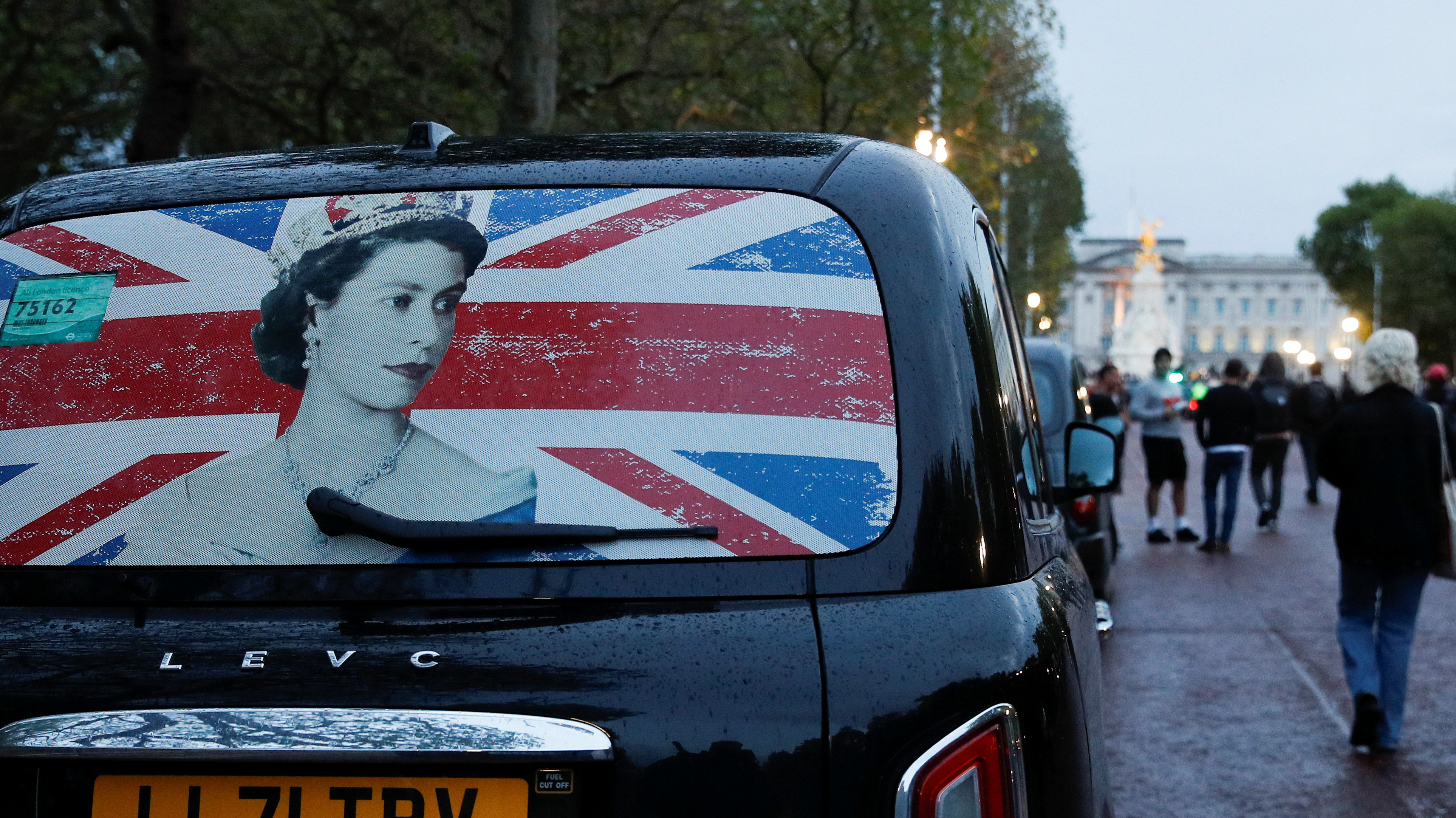 La ventana trasera de un taxi con la imagen de la reina Isabel aparece estacionada cerca del Palacio de Buckingham (REUTERS/Peter Nicholls)
