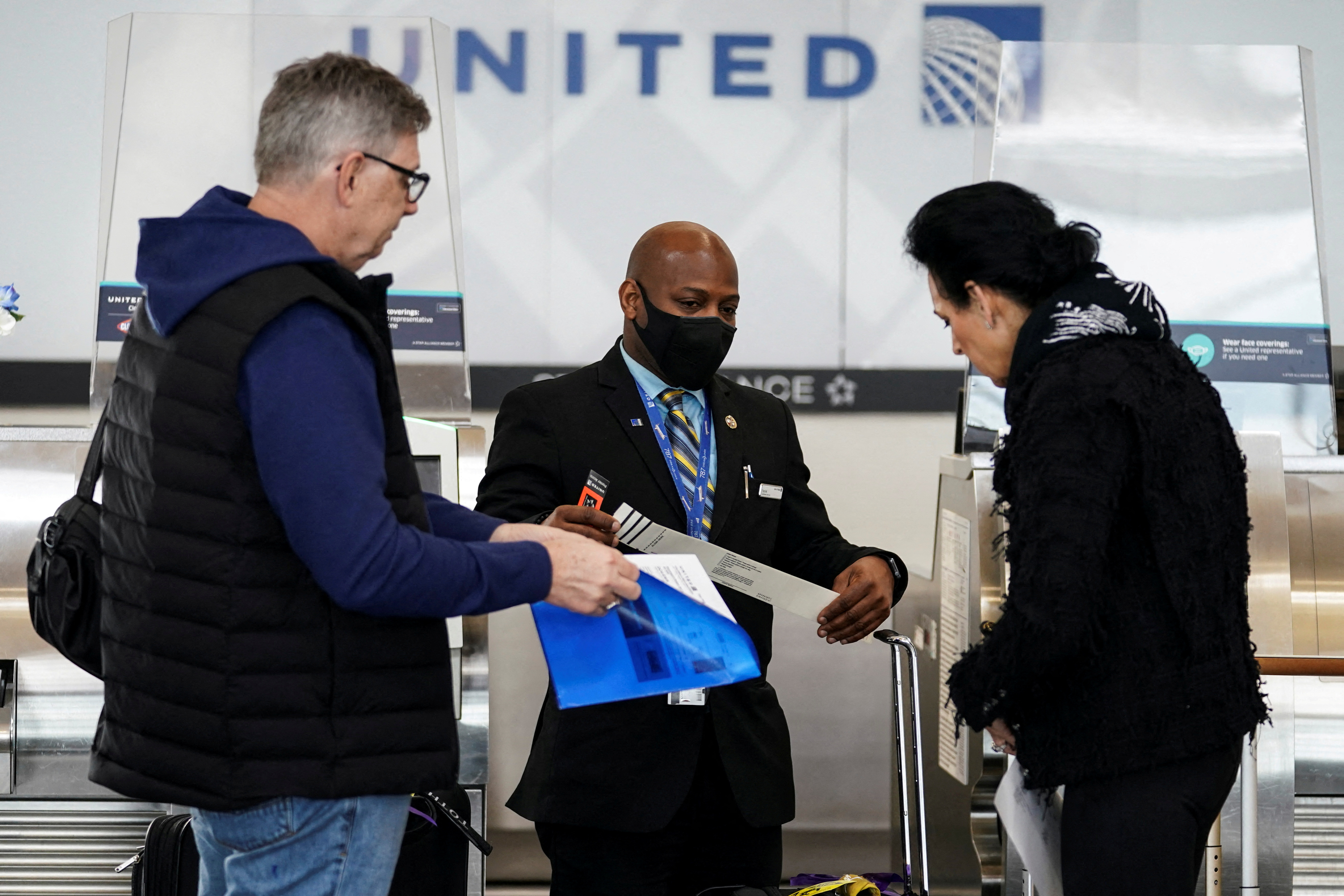 Un trabajador de United Airlines asiste a los viajeros en el aeropuerto nacional Ronald Reagan de Washington, en Arlington, Virginia, Estados Unidos, el 19 de abril de 2022. REUTERS/Kevin Lamarque/Archivo
