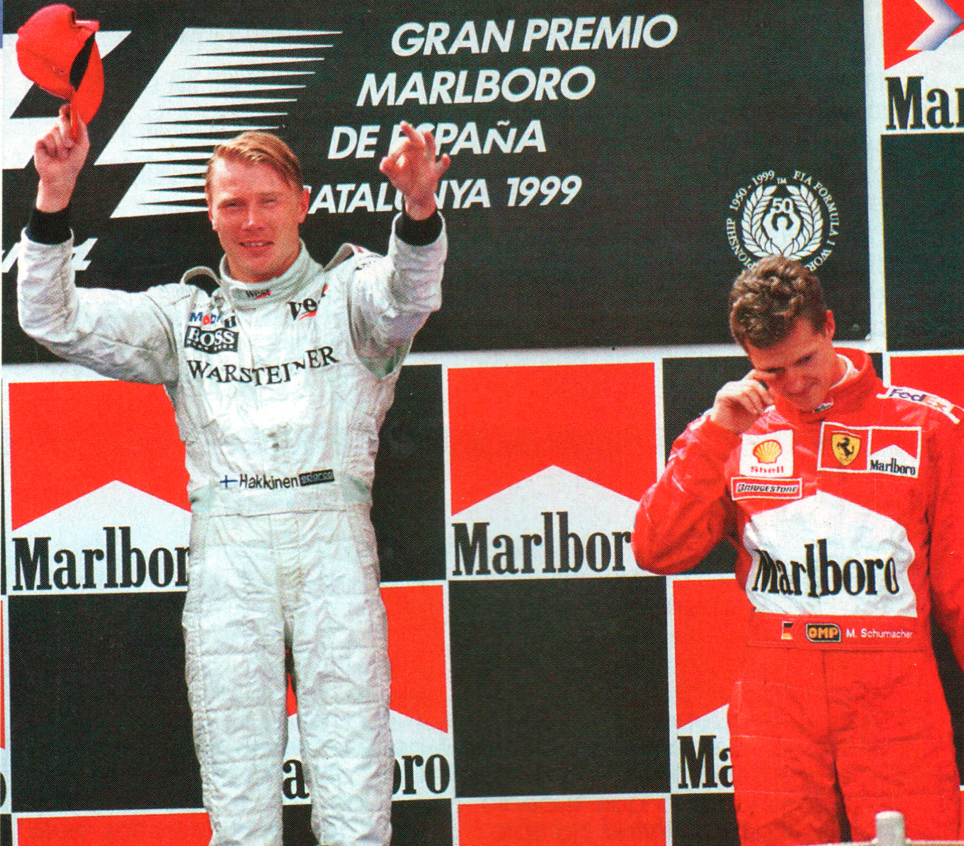 Mika Häkkinen festejando su triunfo en España en 1999. A su lado Michael Schumacher (Archivo CORSA).