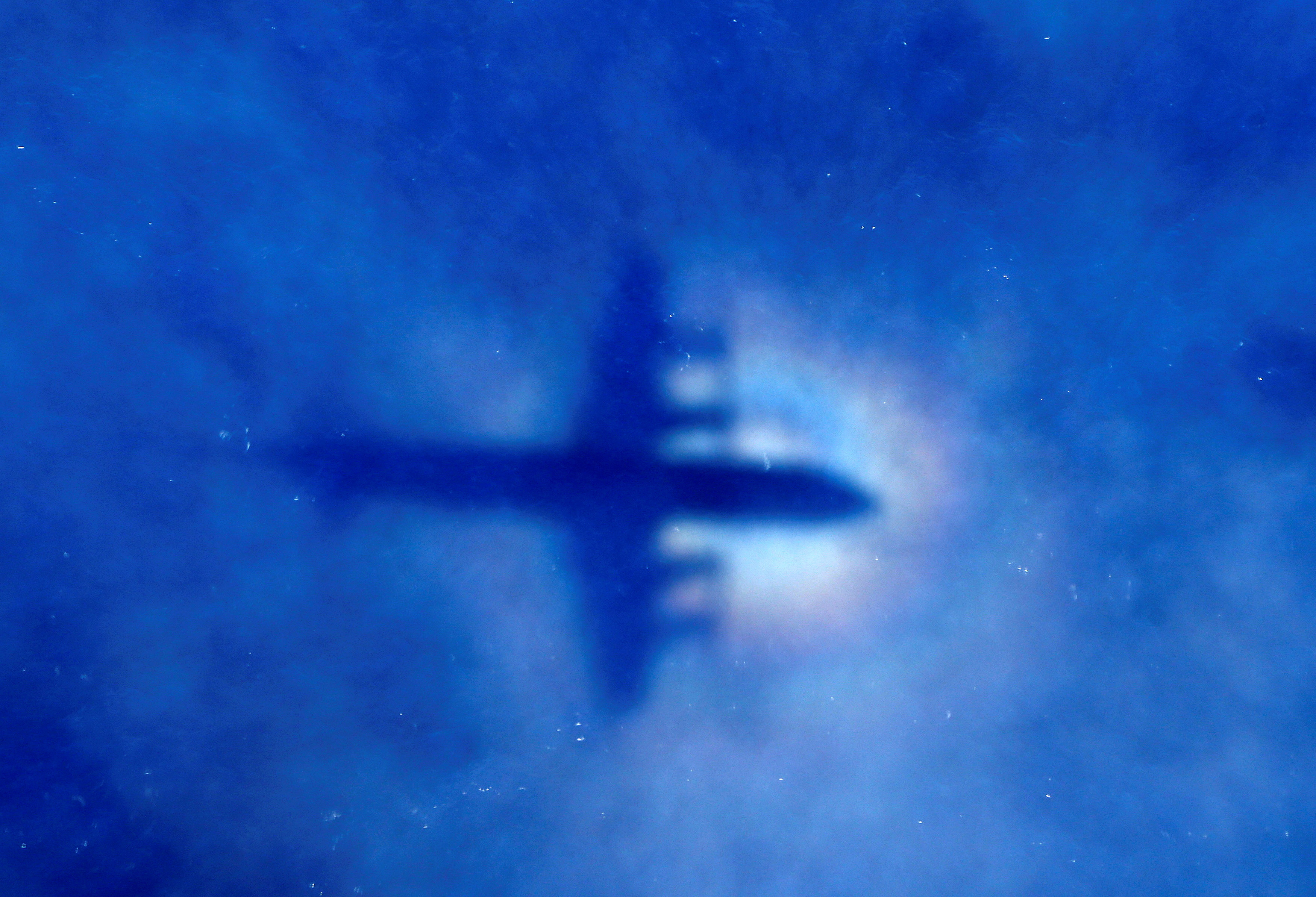 La sombra de un uno de los aviones de los equipos de búsqueda del vuelo MH370 (Reuters)
