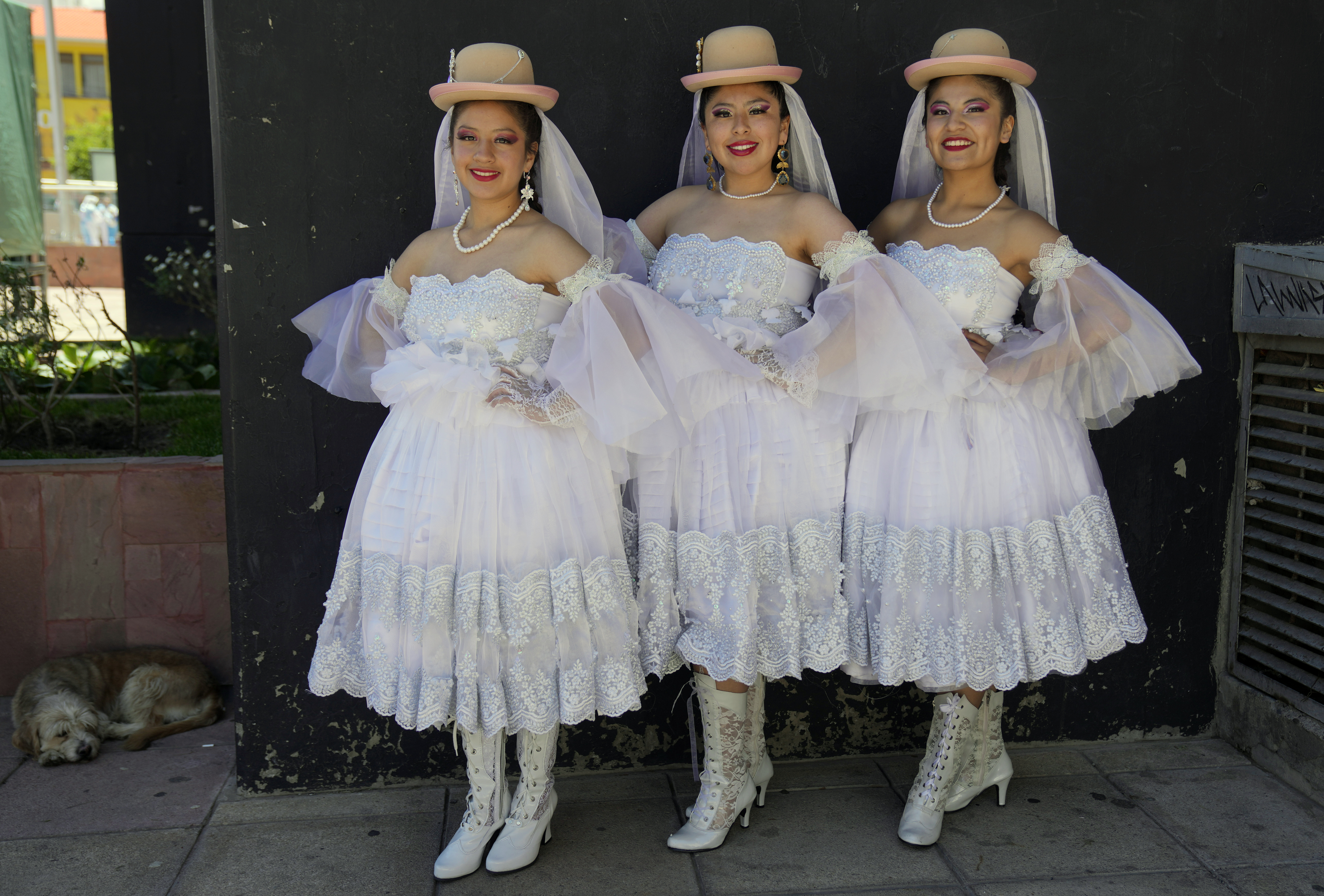Tres mujeres vestidas de novia posan para una foto antes de la boda de Pepino, un personaje del Carnaval, en La Paz, Bolivia, el 12 de febrero de 2023. La parodia de enlace forma parte de los festejos previos al Carnaval. (AP Foto/Juan Karita)