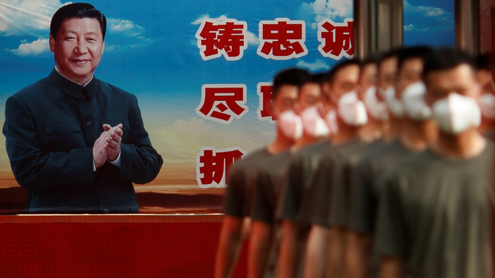 Fuerzas paramilitares chinas formadas frente a un retrato del presidente Xi Jinping (REUTERS/Thomas Peter)