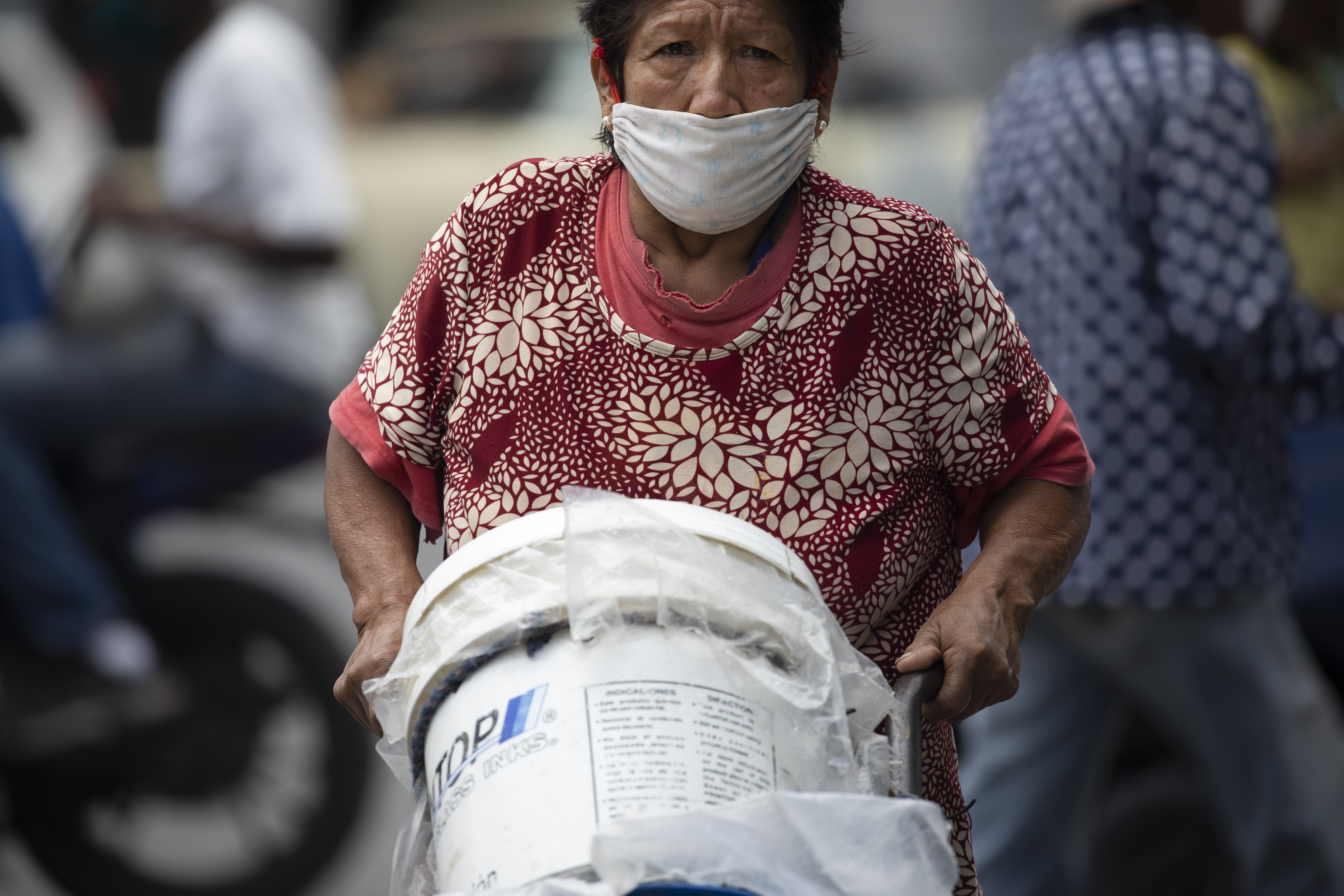 Una mujer, con mascarilla para protegerse del coronavirus, empuja un carrito con recipientes llenos de agua, en Caracas, Venezuela, el 20 de junio de 2020. Se estima que el 86% de los venezolanos reportó problemas con el suministro de agua, incluyendo un 11% que no tiene, según una encuesta realizada por la ONG Observatorio Venezolano de Servicios Públicos entre 4.500 residentes en abril. (AP Foto/Ariana Cubillos)