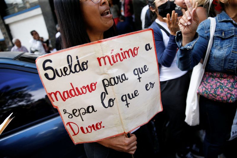 FOTO DE ARCHIVO: Un maestro sostiene un cartel que dice "Salario mínimo a Maduro para que sepa lo  que es duro"  (REUTERS/Leonardo Fernández Viloria)