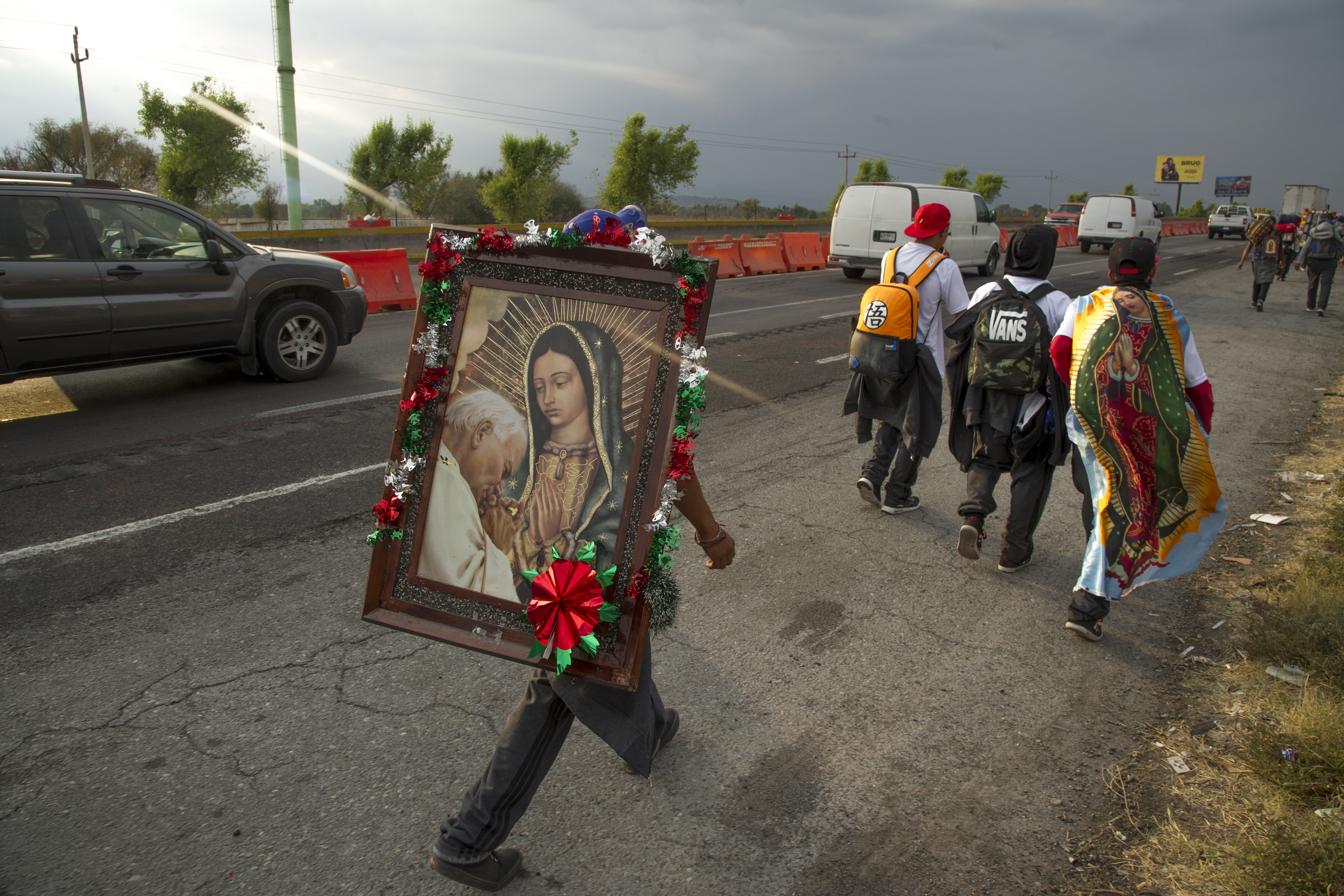 Los peregrinos llevan imágenes de la Virgen de Guadalupe mientras caminan por una carretera federal en Puebla, México, de camino a la Basílica de Guadalupe en la Ciudad de México, el 7 de diciembre de 2020.