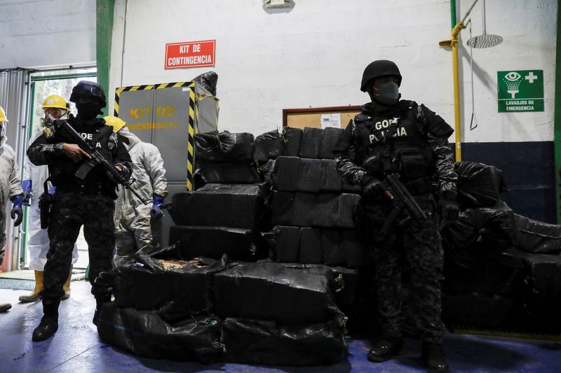 Agentes de policía vigilan sacos que contienen paquetes de cocaína en un almacén en un lugar no revelado, en Ecuador (REUTERS/Karen Toro)