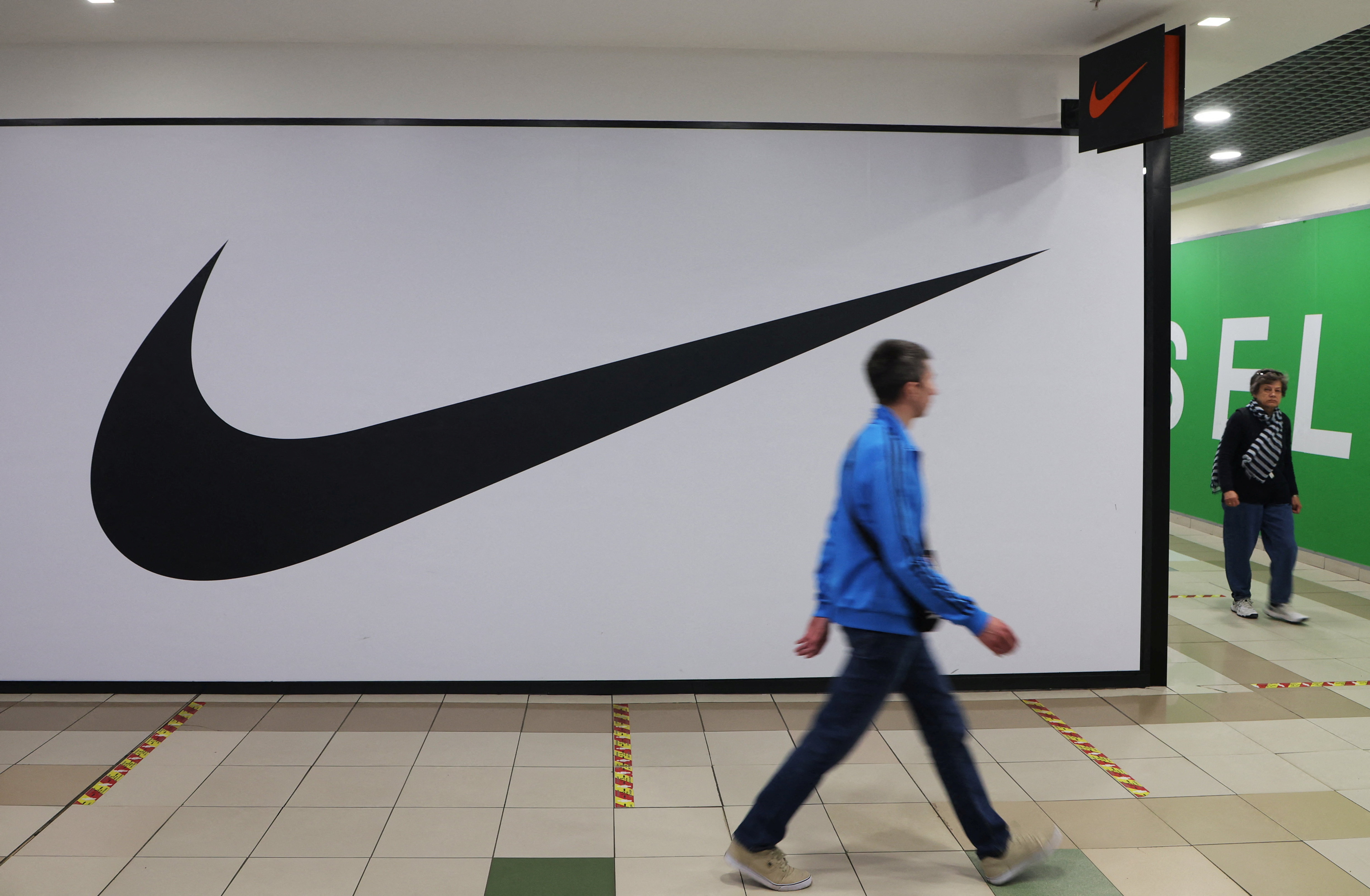 25. mai 2022 går folk forbi Nikes lukkede butikk, en leketøyselger, i et kjøpesenter i St. Petersburg i Russland.  REUTERS / Anton Vaganov