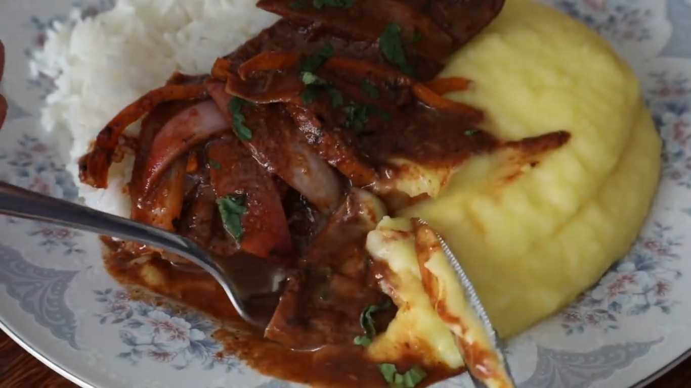 Fígado frito e cebola em uma panela, com mostarda e ketchup, em