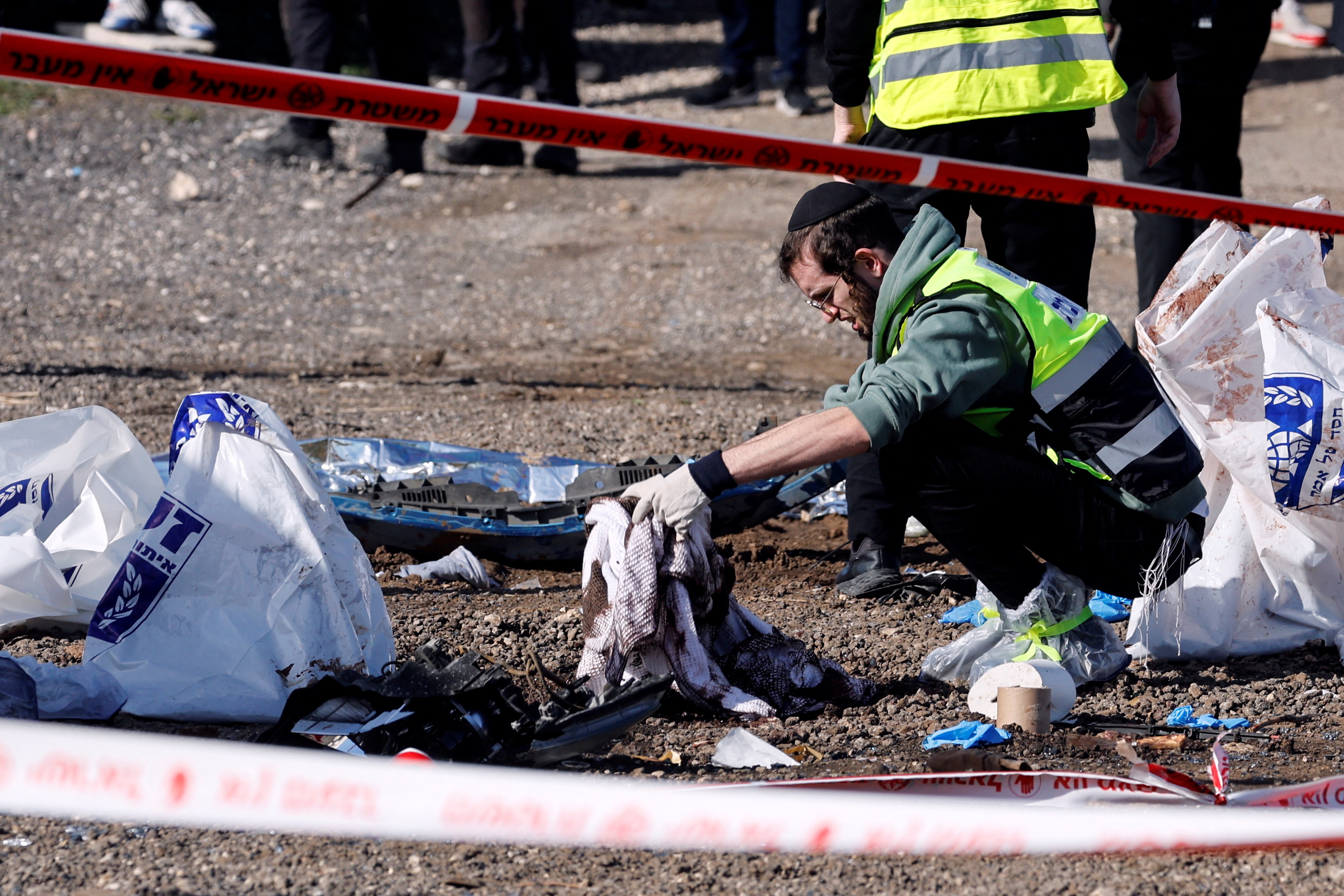 Un trabajador de rescate israelí limpia las manchas de sangre de la escena donde tuvo lugar ateque con embestida en Jerusalén, 10 de febrero de 2023. REUTERS/Ammar Awad